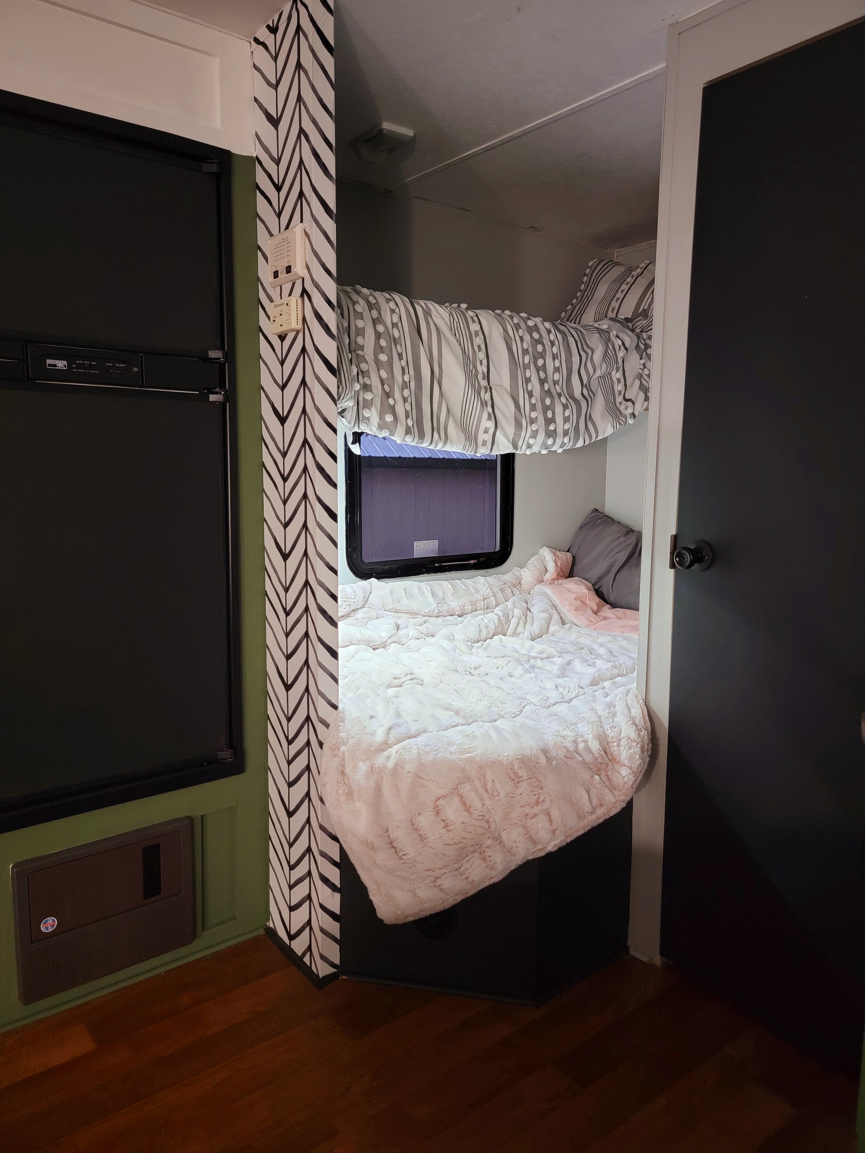 Cozy RV rental interior featuring bunk beds, refrigerator, and stylish black and white patterned wall. Perfect for families!. Gulf Stream Conquest-Lite 2009