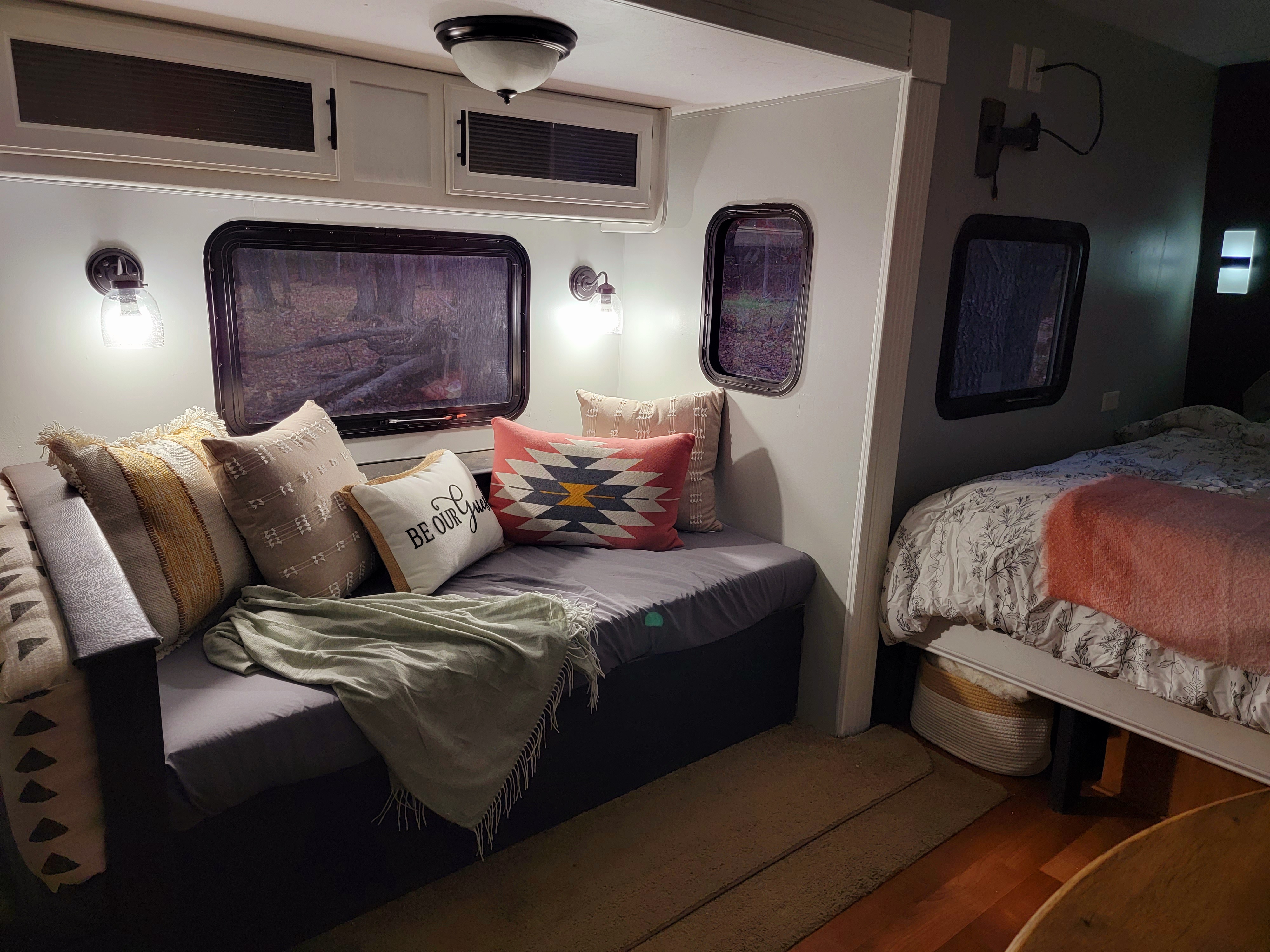 Cozy RV rental interior featuring a daybed with pillows, windows, and a glimpse of a bedroom area.. Gulf Stream Conquest-Lite 2009