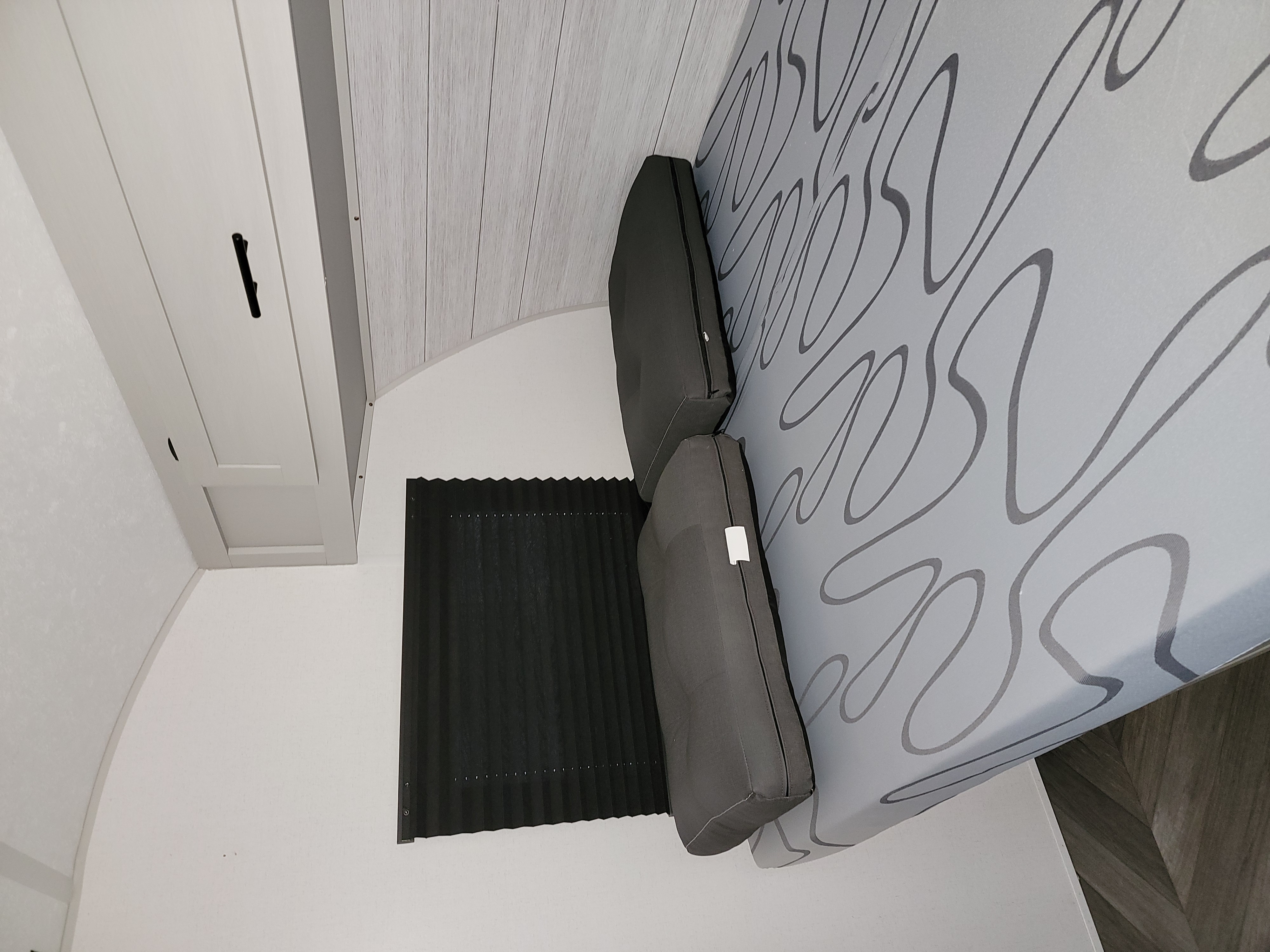 RV rental: Cozy bed area with grey patterned mattress, dark cushions, and black accordion blind.. Forest River Salem FSX 2021