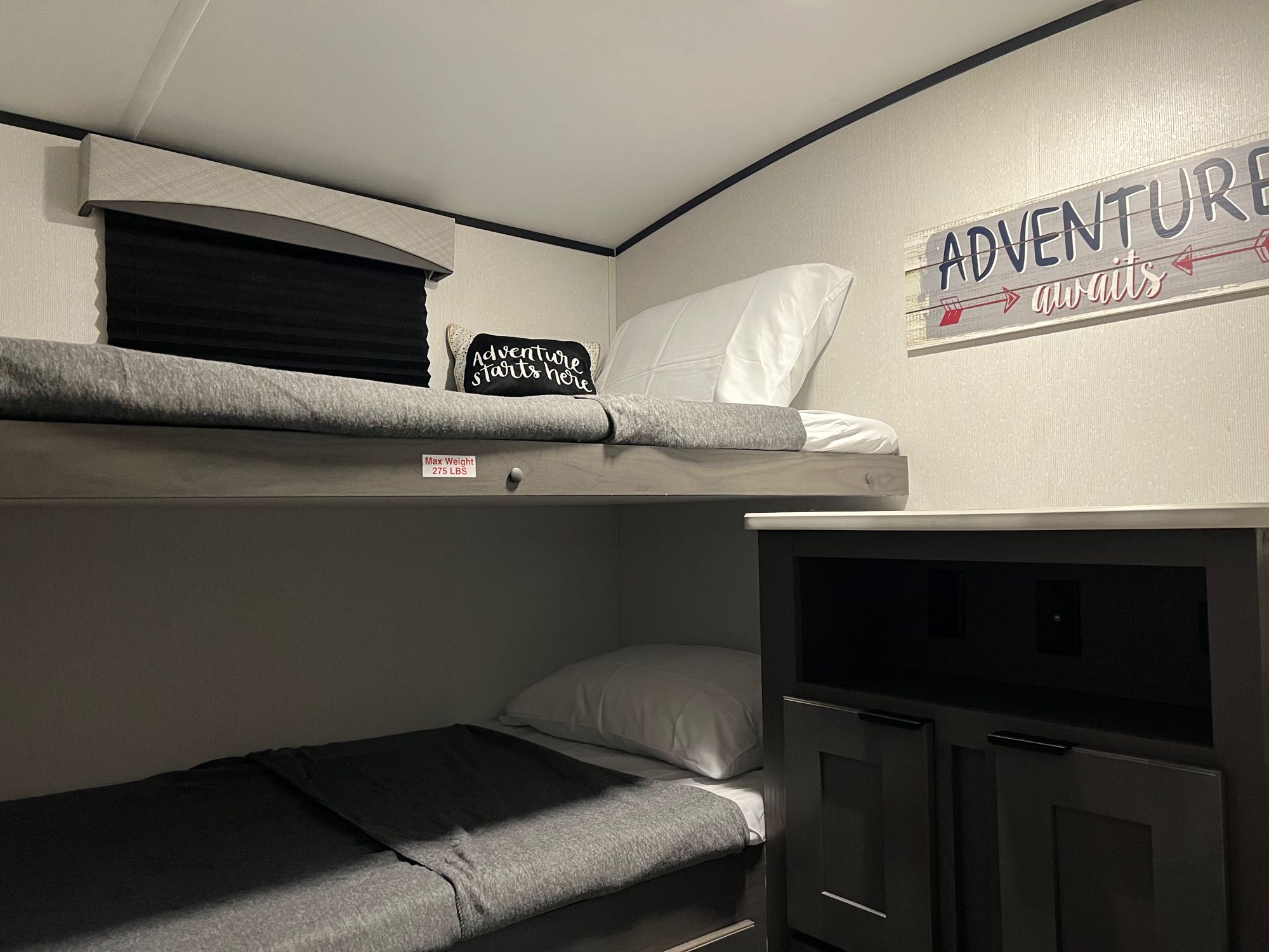 Cozy RV rental bunk beds (top bunk max weight 275 lbs) with "Adventure awaits" decor in the interior.. Cruiser RV EL280 2021