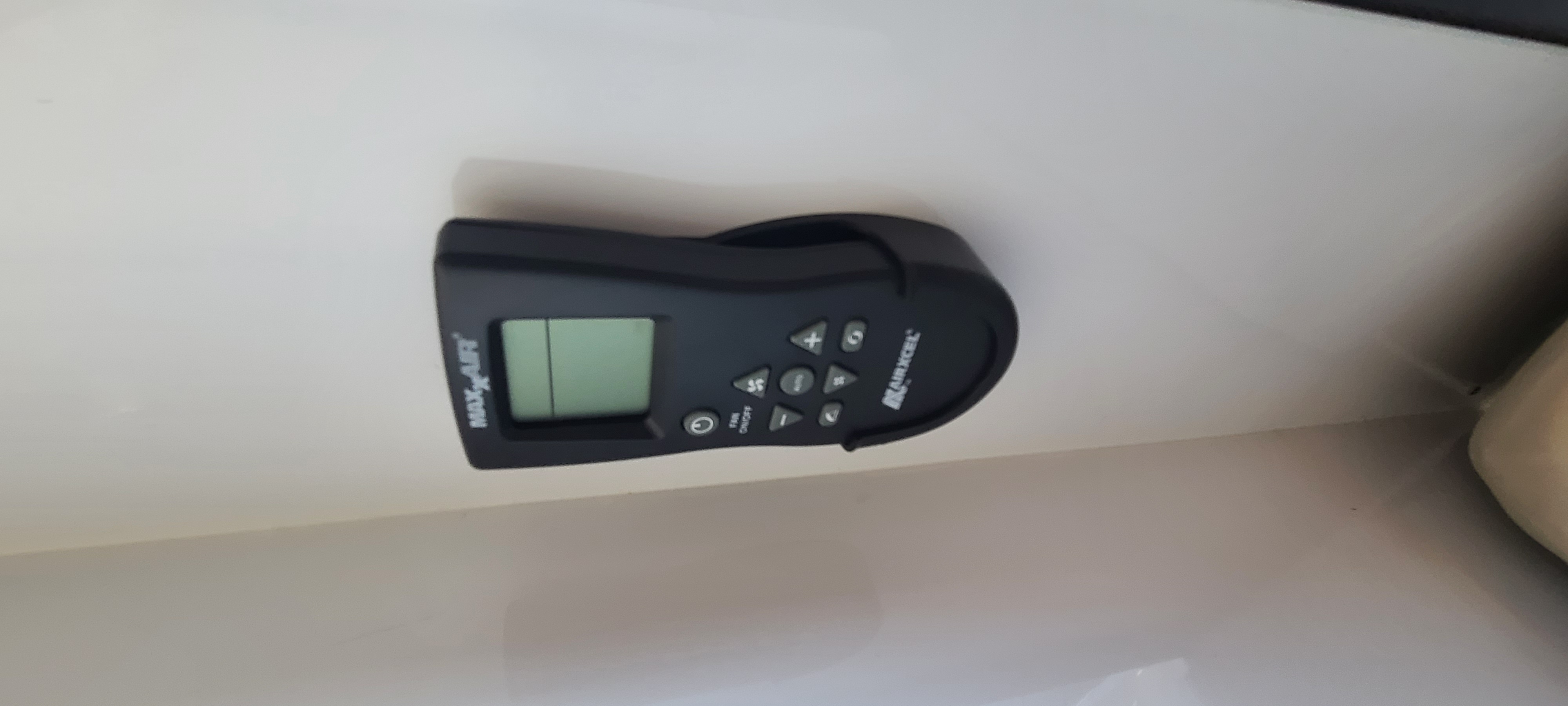 Black MaxxAir fan remote control for an rv rental, featuring a digital screen and buttons to manage climate. Essential RV comfort.. Off Grid Trailers Off Grid Trailers Trailer 2021