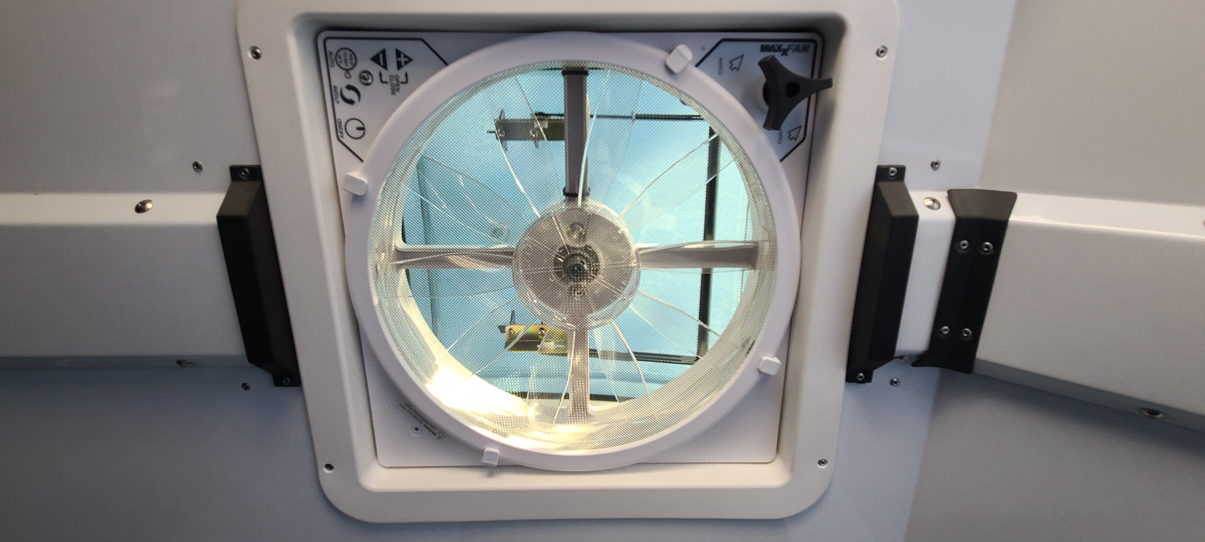 RV rental interior: A white Maxx Air ceiling fan offers ventilation and a clear view of the blue sky overhead.. Off Grid Trailers Off Grid Trailers Trailer 2021