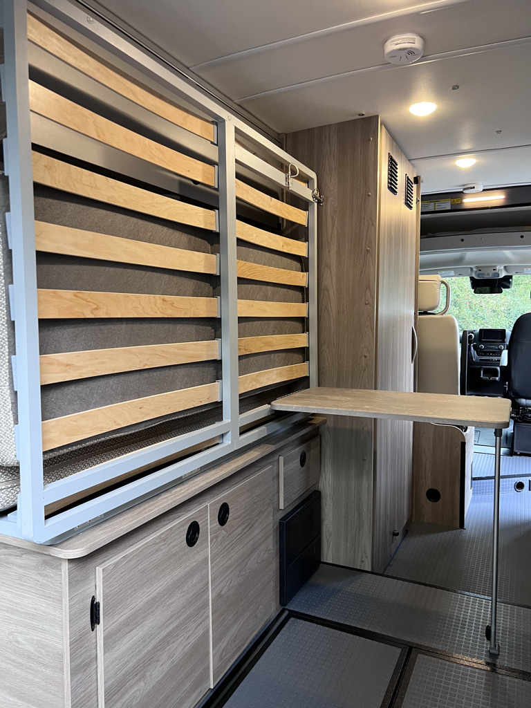 Inside this RV rental, see the space-saving design: a fold-up bed, retractable table, and built-in storage optimize comfort.. Winnebago Solis 59PX 2023