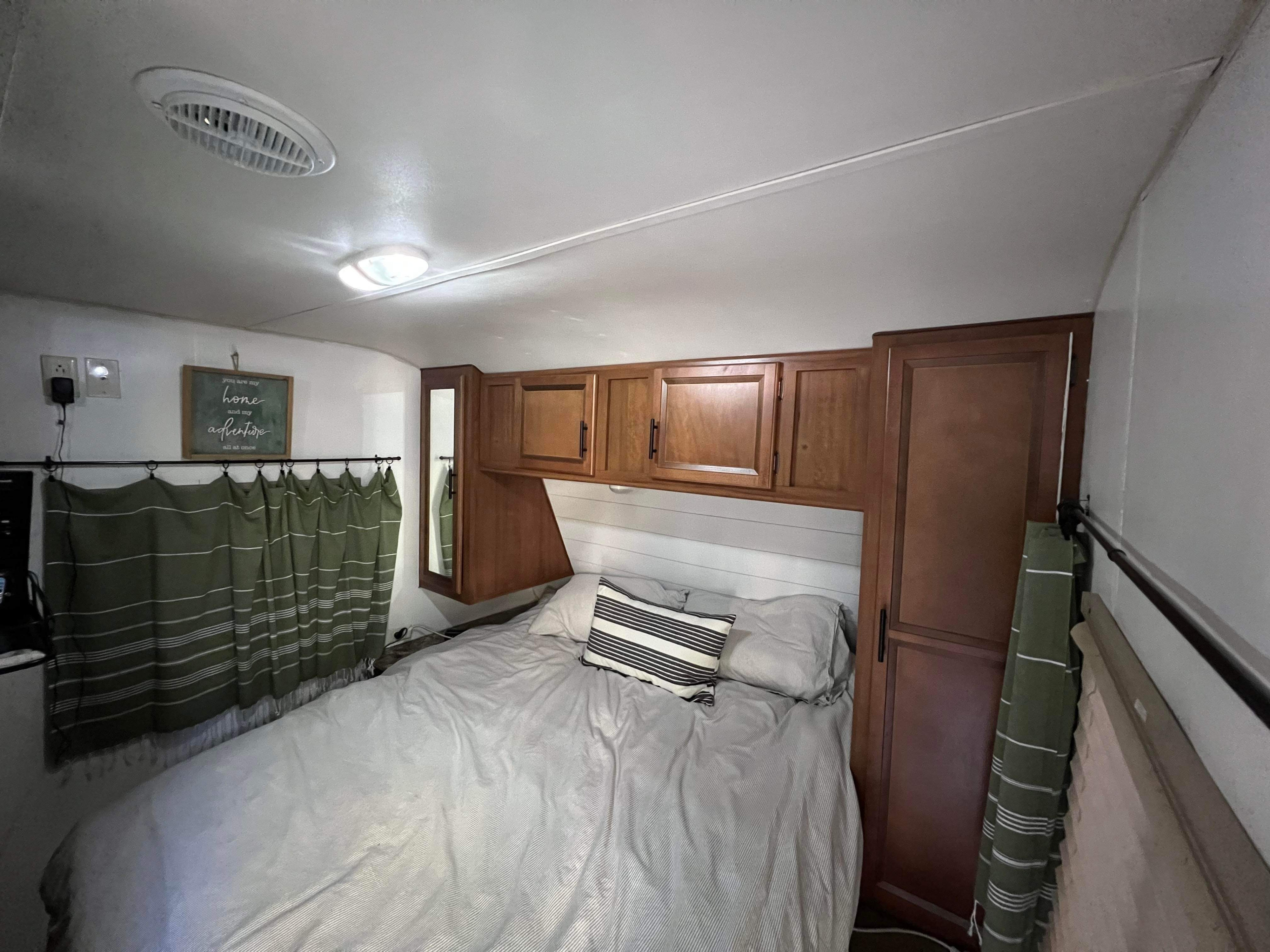 Step into comfort with this RV rental bedroom featuring a full bed, storage cabinets, and charming decor.. Gulf Stream Conquest 2015