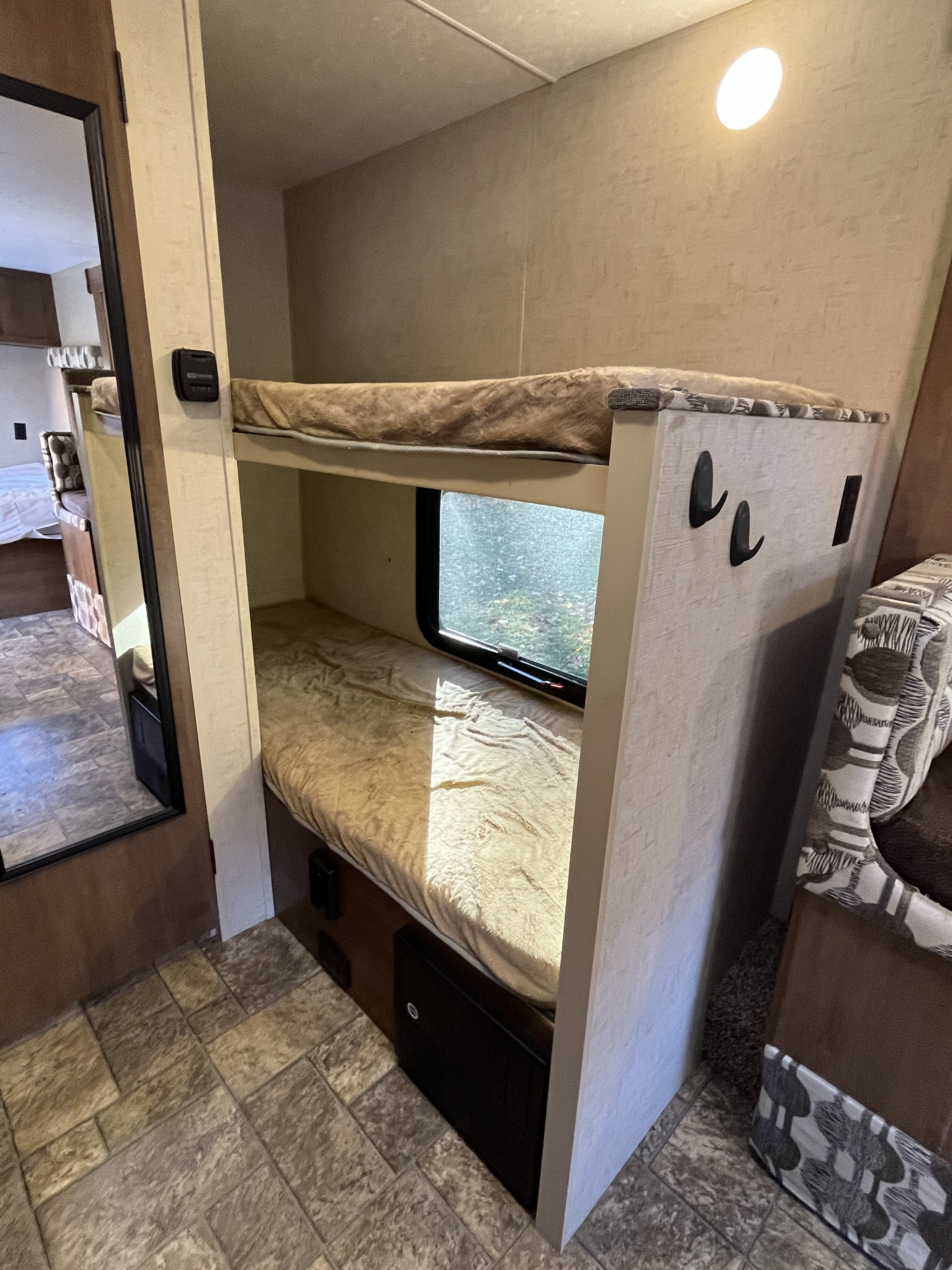 Explore this RV rental's cozy bunk beds, complete with a window view and functional interior design.. Sportsmen Classic 2017