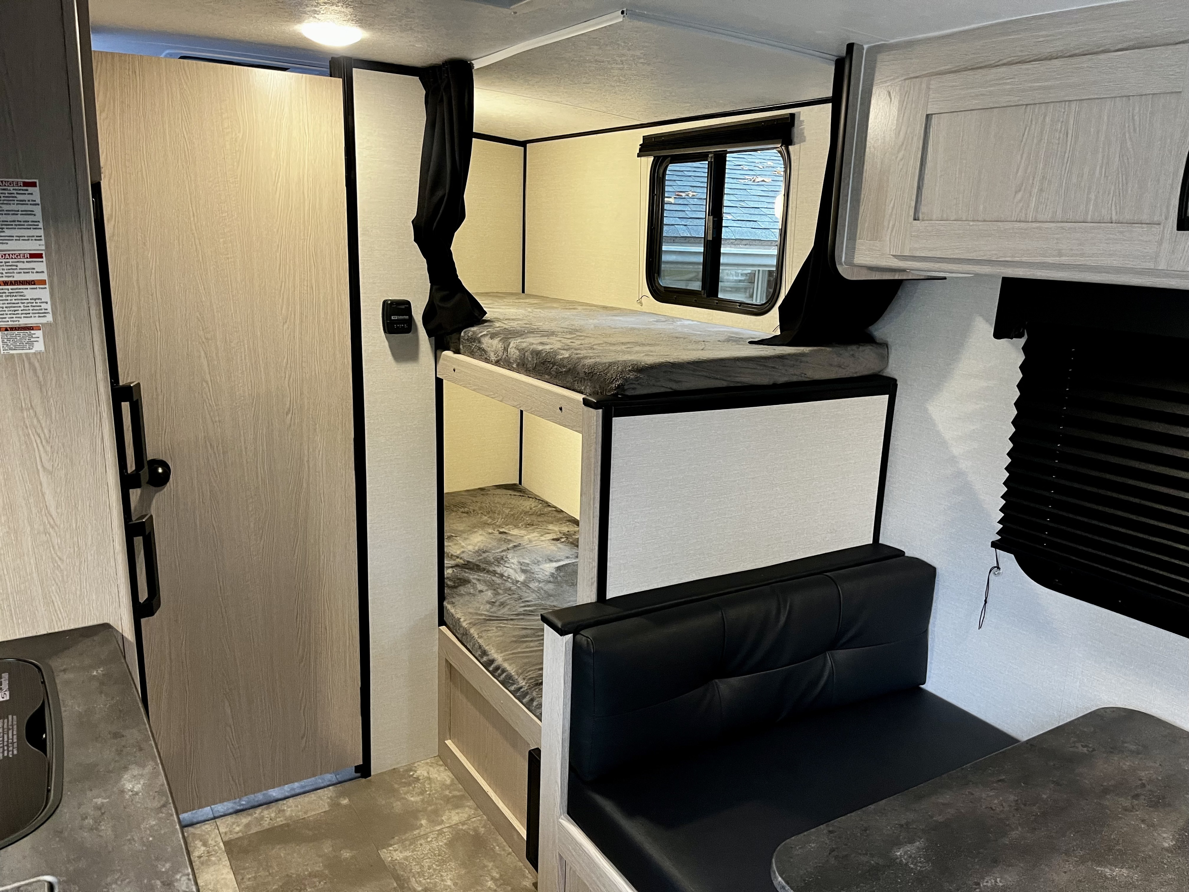 Bathroom door, bunks, dinette. Coachmen Apex Nano 2022