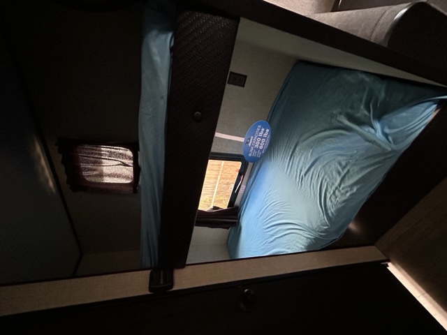 RV rental interior: two stacked bunk beds with blue sheets. A tag shows 300 lbs capacity, ideal for family travel.. Jayco Jay Flight SLX 2022