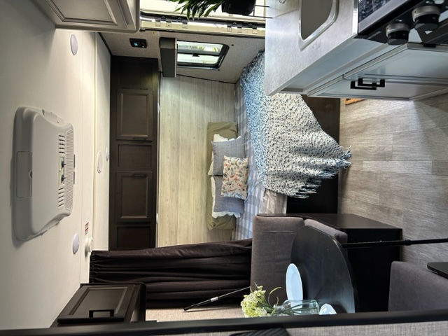 View inside an RV rental, showing the open floor plan with a bed, kitchen counter, and seating area.. Jayco Jay Flight SLX 2022