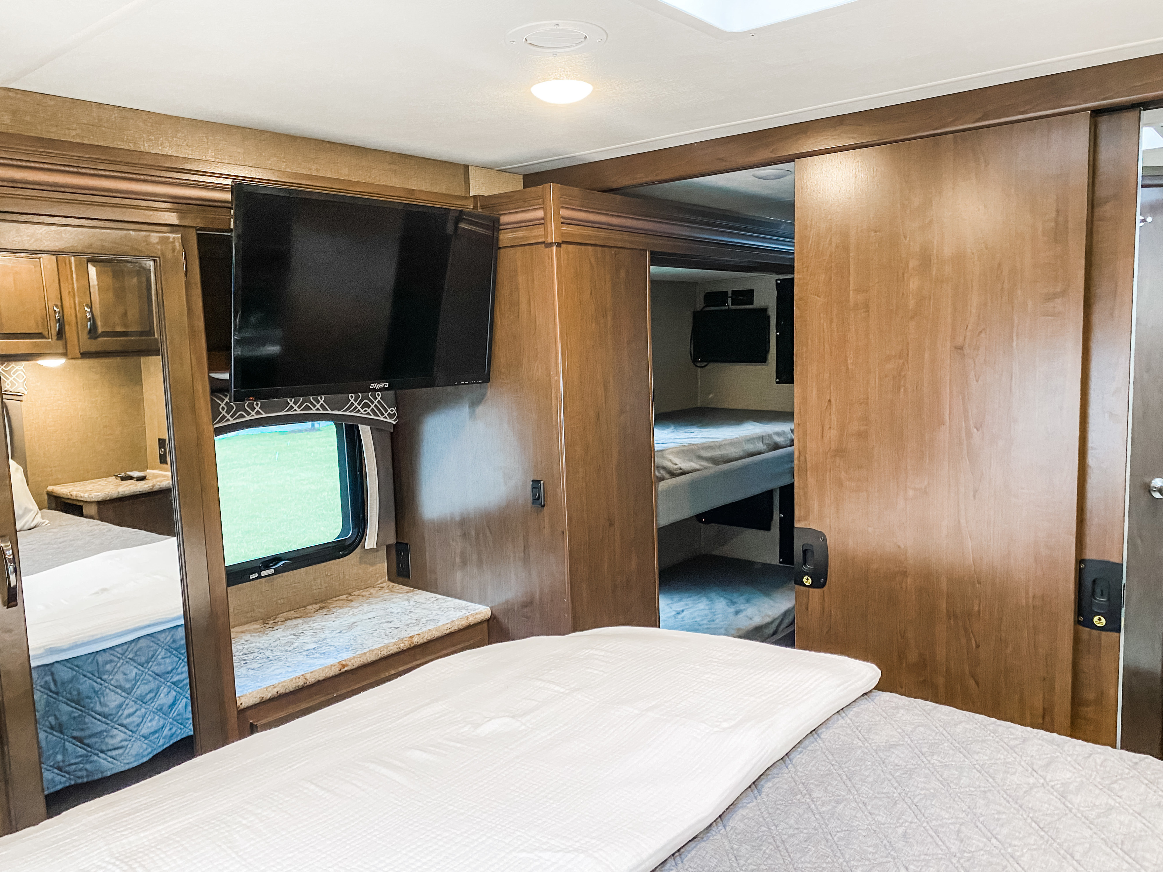 Spacious RV rental interior with a bedroom, TV, and separate bunk room, offering comfortable family travel.. Other Chateau 2019