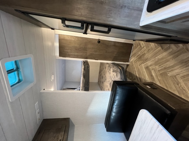 RV rental interior: view of the kitchen counter, two bunk beds with mattresses, and a black dinette seating area.. Forest River EVO Select 268 BH 2022