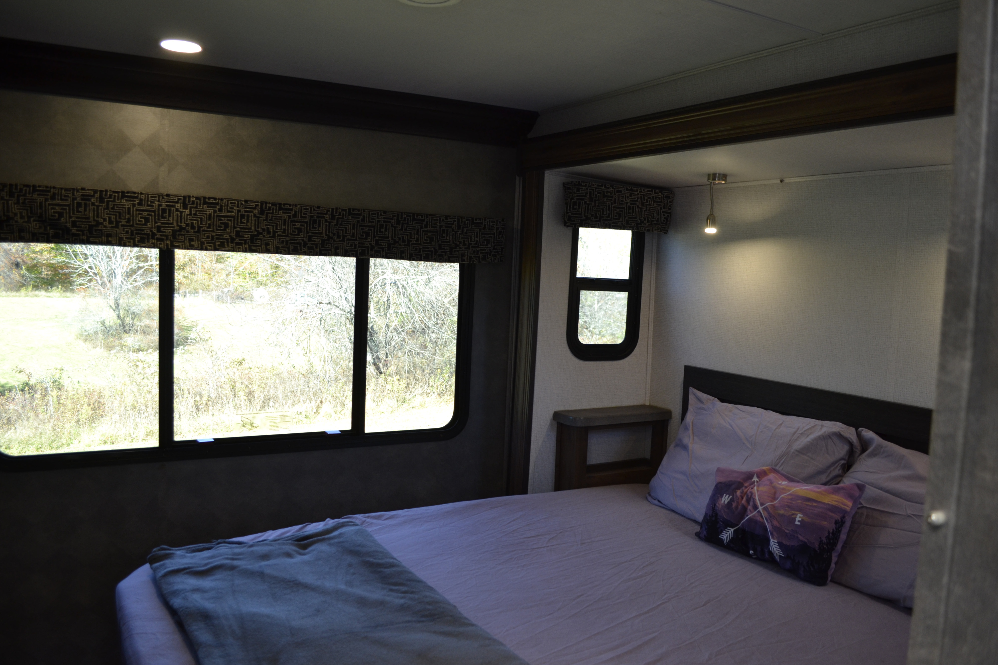 Spacious RV rental bedroom featuring a large window with a scenic view, comfortable bed, and compact design. Perfect for your next adventure.. Forest River Sunseeker Classic 2021