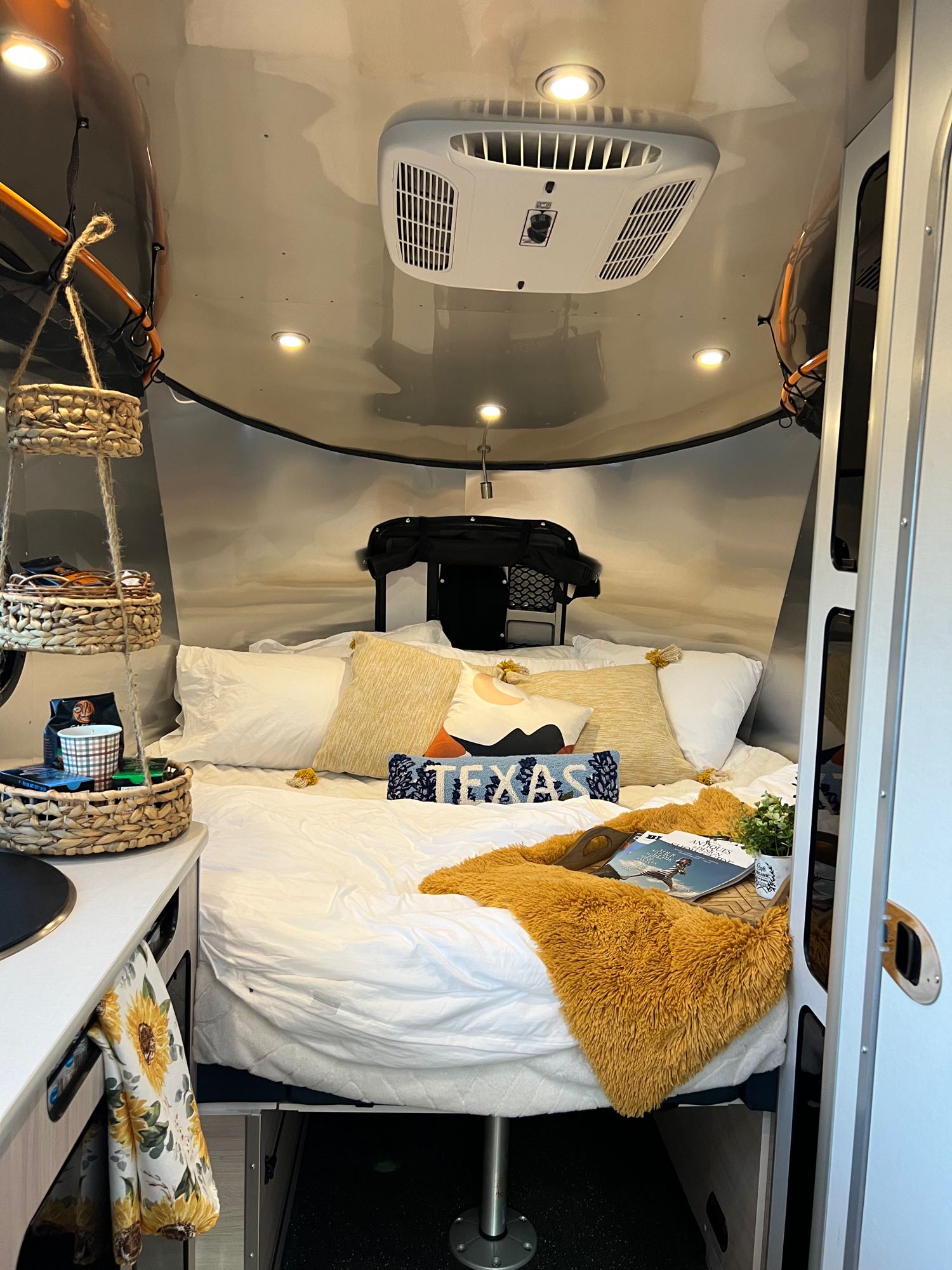 Lounge area converted into king size bed with mattress topper. Airstream Basecamp 2022