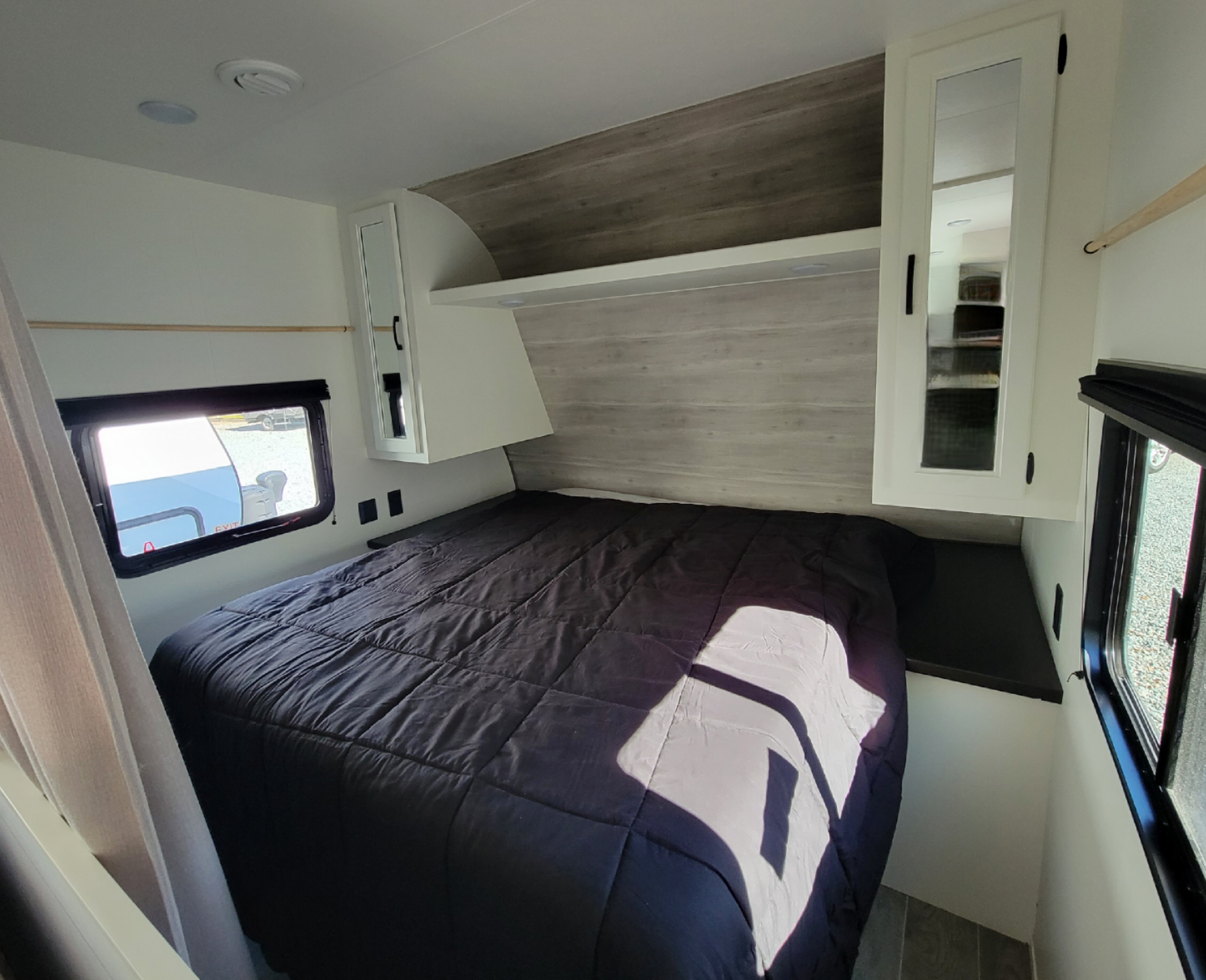 Bright RV rental bedroom with a large bed, overhead storage, and ample windows, offering natural light.. Jayco Jay Flight SLX 2021