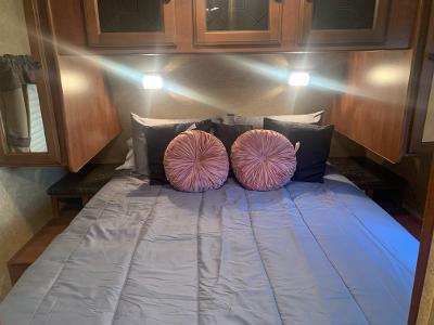 Cozy RV rental bedroom featuring a comfortable bed, accent pillows, and warm lighting for your journey.. Heartland RVs North Trail 2012