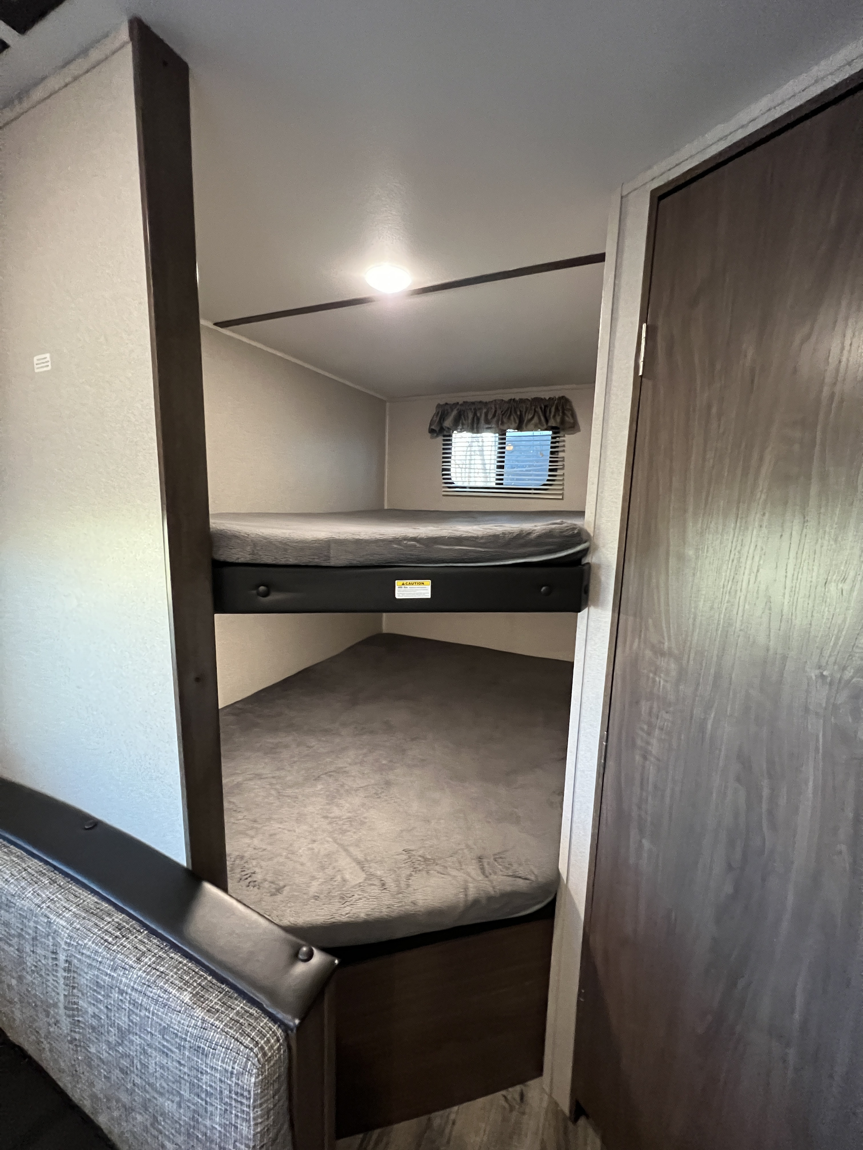 RV rental featuring cozy bunk beds, a window, and ceiling light – perfect for travel trailer camping.. Keystone RV Hideout LHS 2020