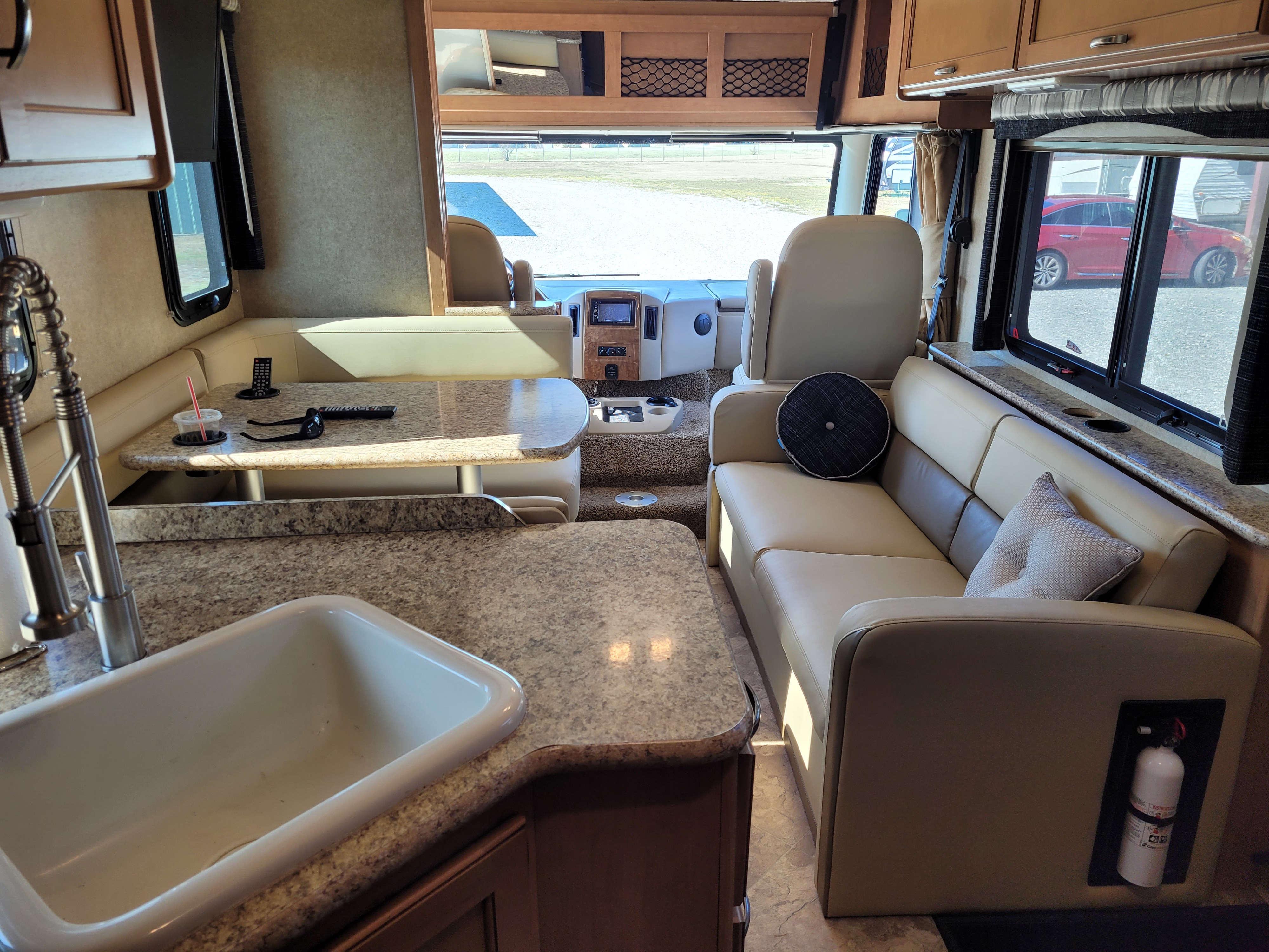 Inside this inviting RV rental: A well-appointed interior featuring a kitchen, dining area, comfy sofa, and cockpit ahead.. Thor A.C.E. 2017
