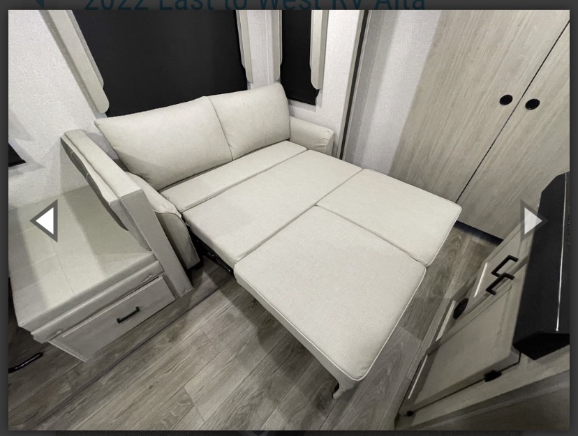 RV rental interior: A light-colored sofa converts to a bed, offering versatile sleeping & seating in this modern compact living space.. East to West Alta 2022