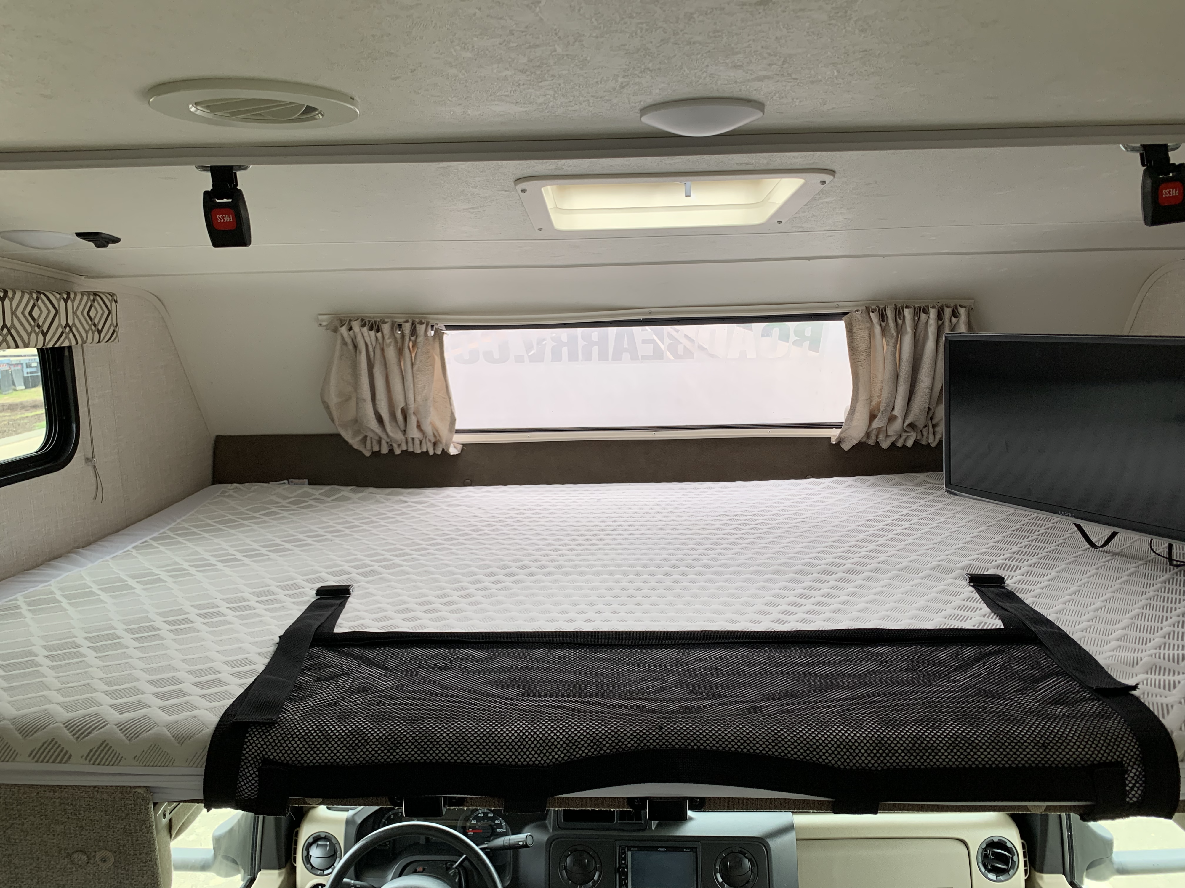 RV rental: The cab-over bunk features a textured mattress, safety net, windows, curtains, and a TV for comfort.. Forest River Coachmen Leprechaun 2020