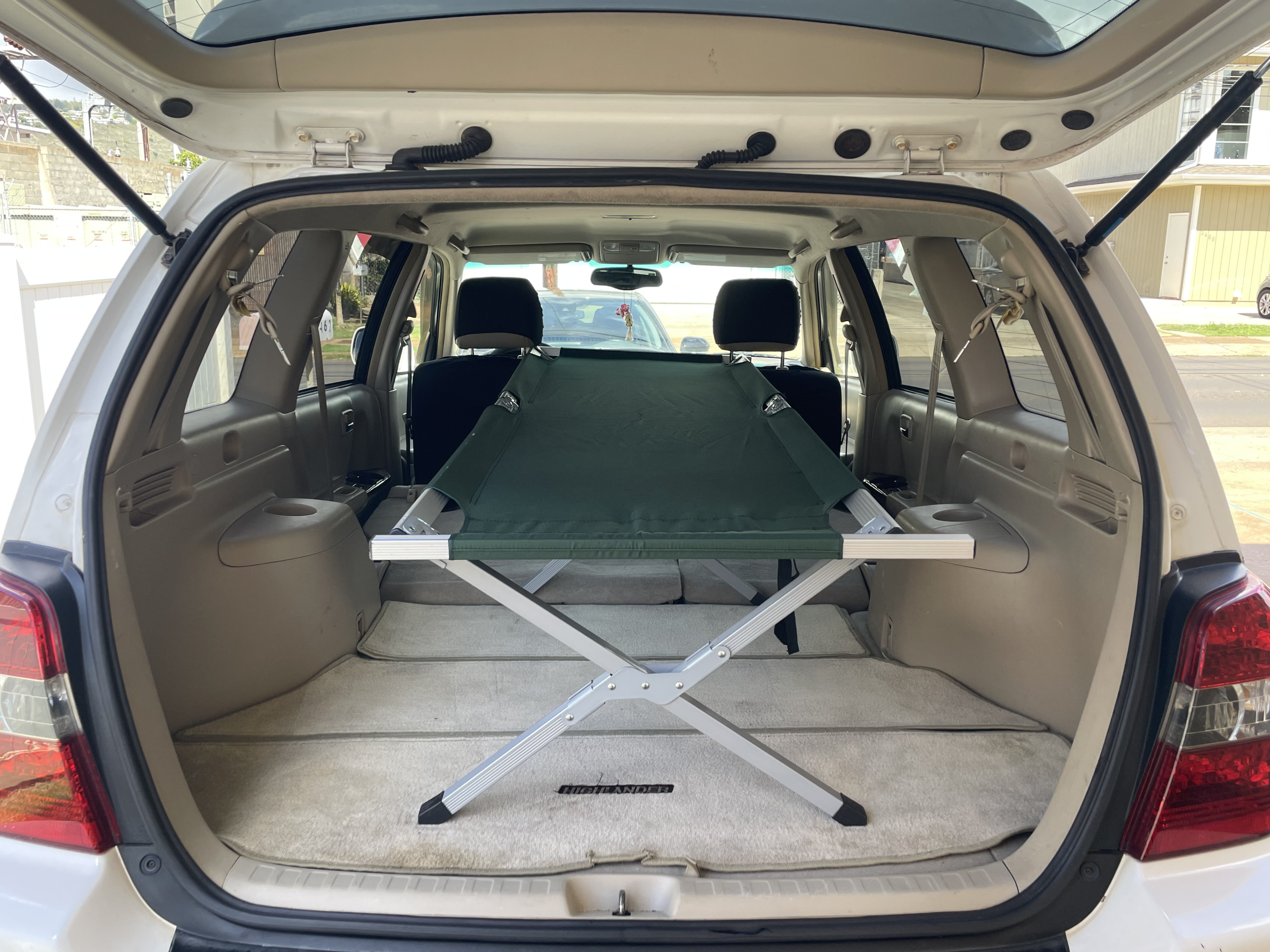 Toyota Highlander SUV cargo area ready for an adventure. A folding cot turns it into a compact RV rental option.. Toyota Highlander 2005