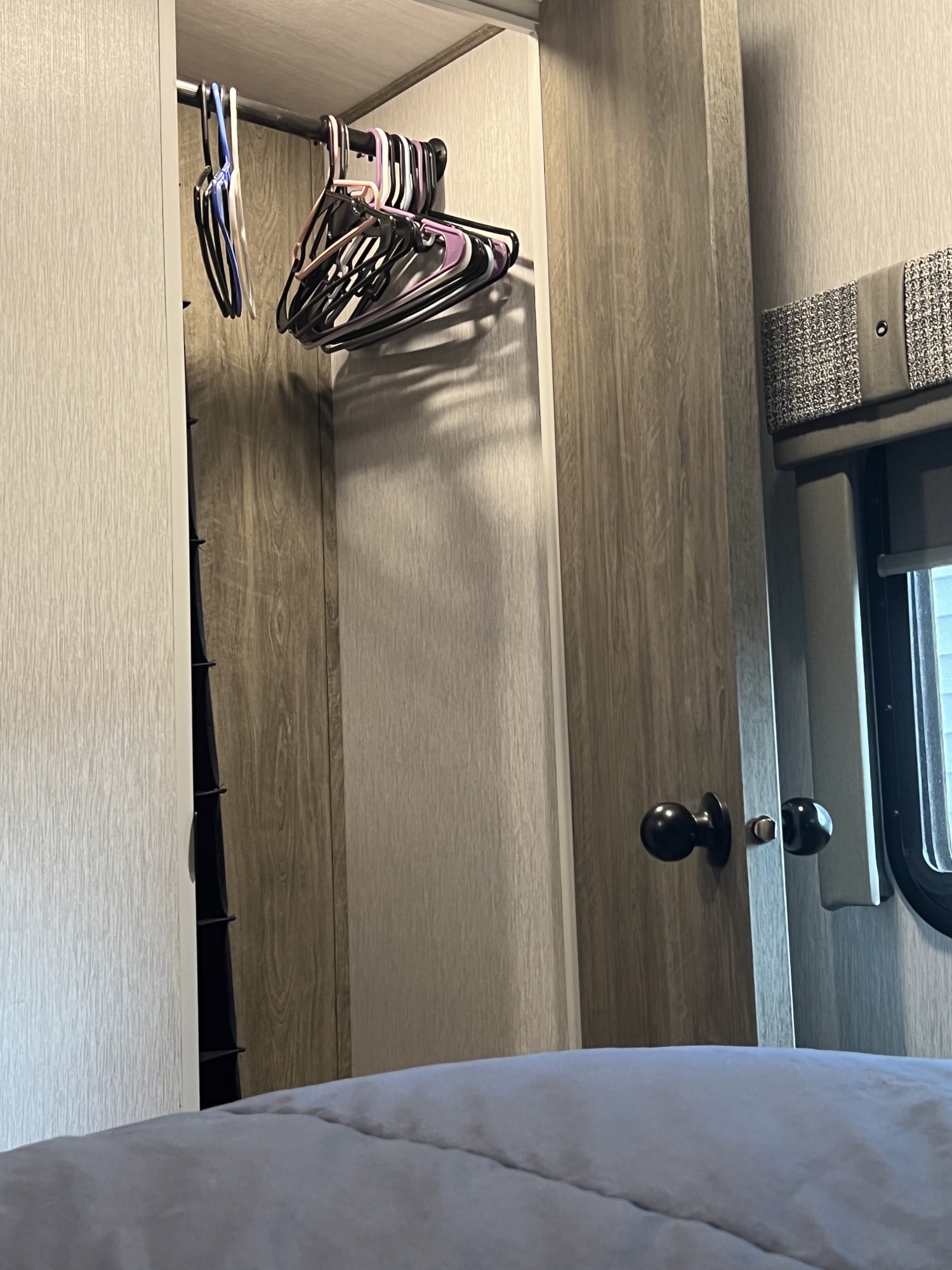 RV rental bedroom: practical closet with hangers, comfy bed, and window. Your travel storage solution.. Forest River Salem Hemisphere 2022