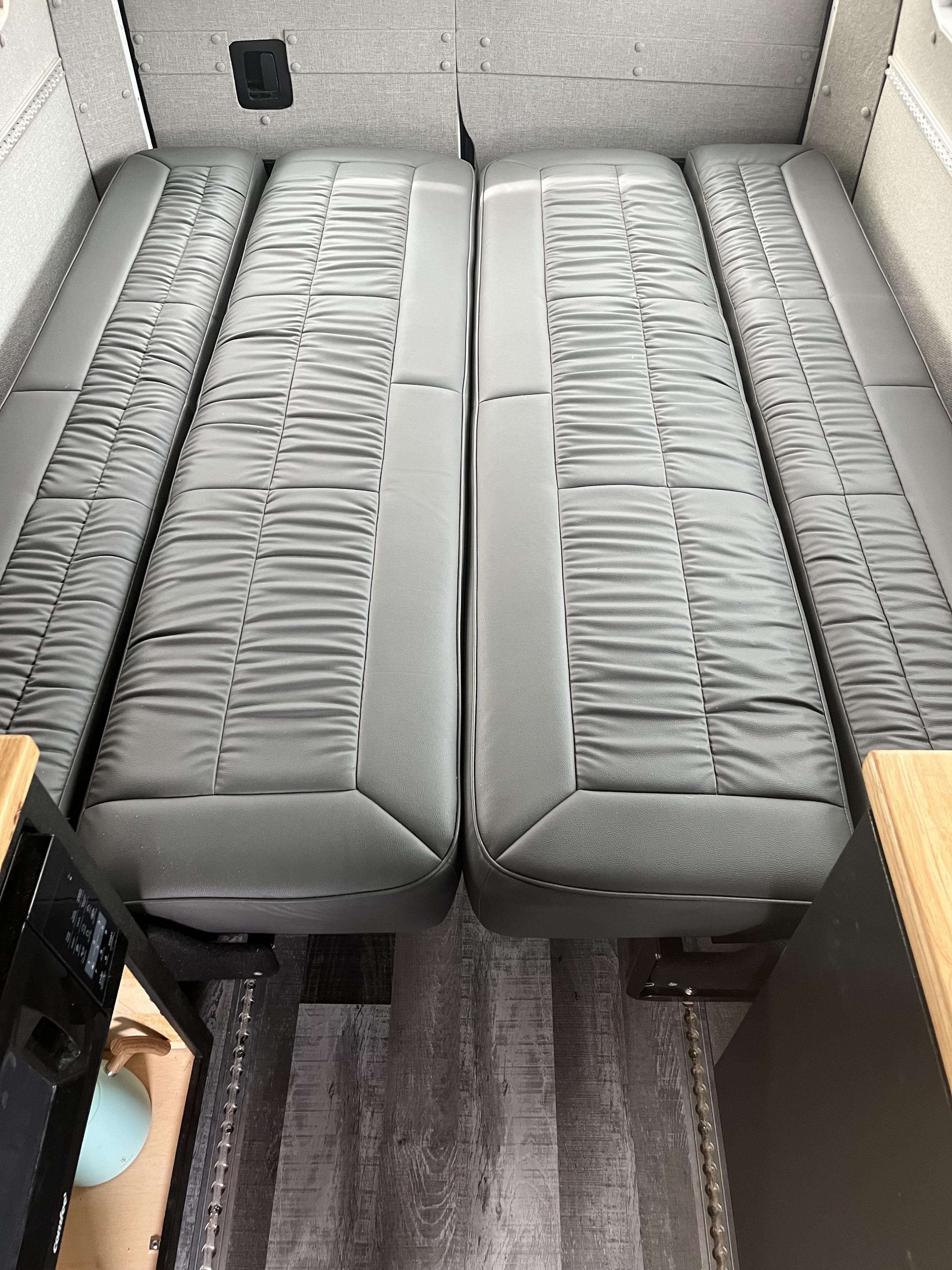Spacious grey faux leather seating transforms into comfortable beds in this RV rental interior.. Mercedes Sprinter 2019