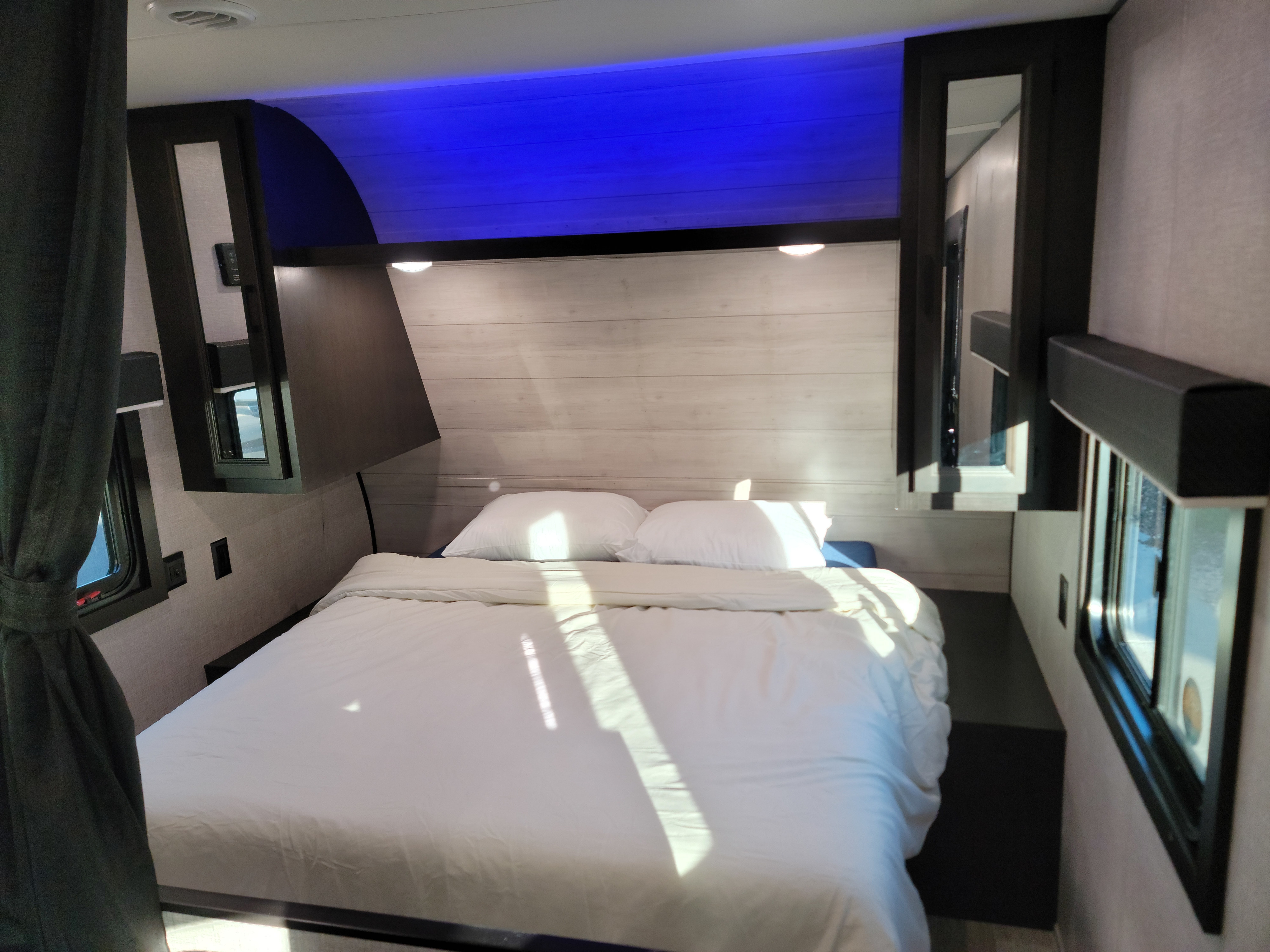 Step inside this inviting RV rental bedroom. Features a comfy bed, modern lighting, and ample storage for travel.. Jayco Jay Flight SLX 2022