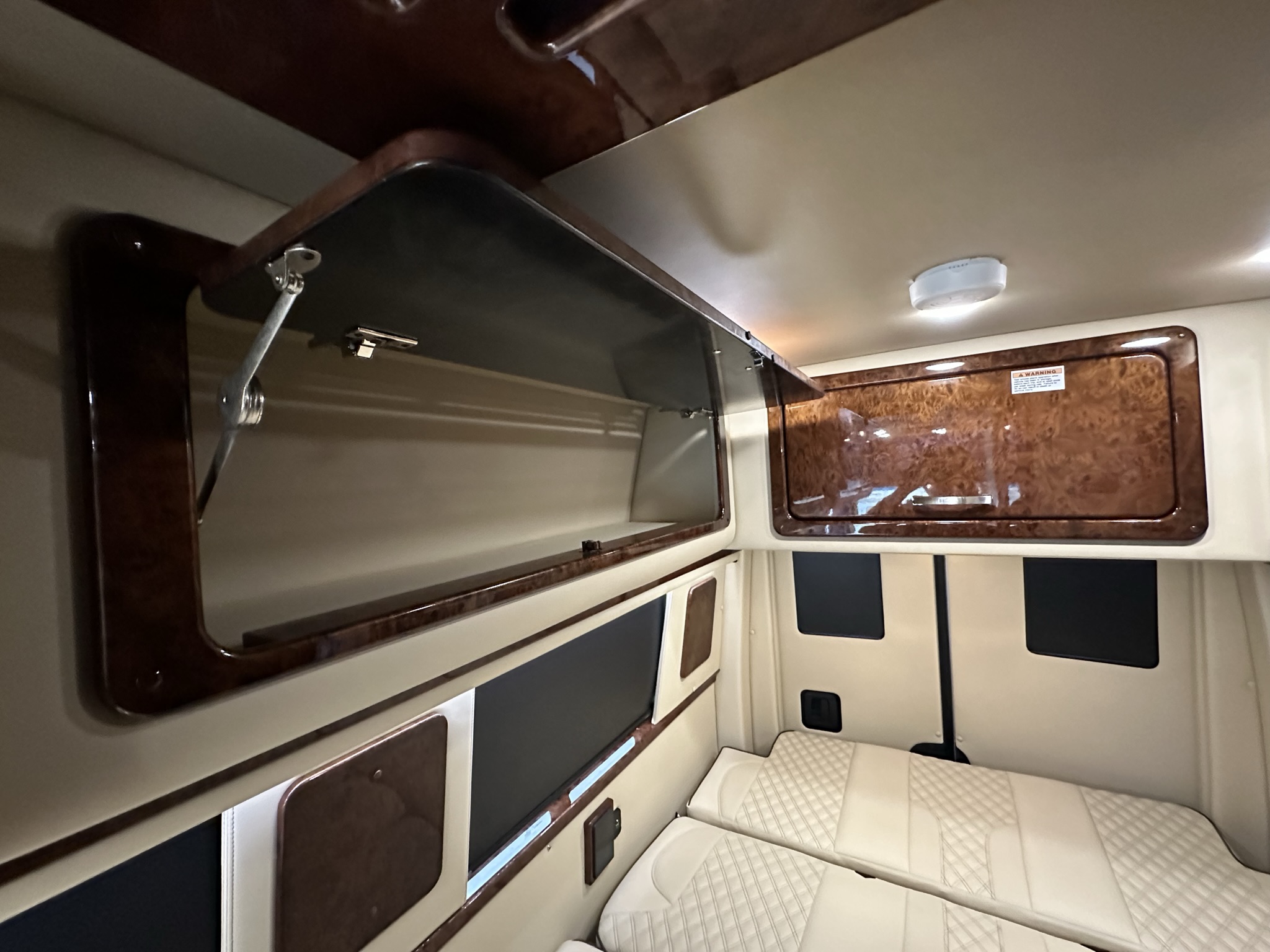 Experience this RV rental's inviting interior: open overhead storage, comfy quilted seating, and elegant wood-grain finishes.. American Patriot American Patriot Class B 2021