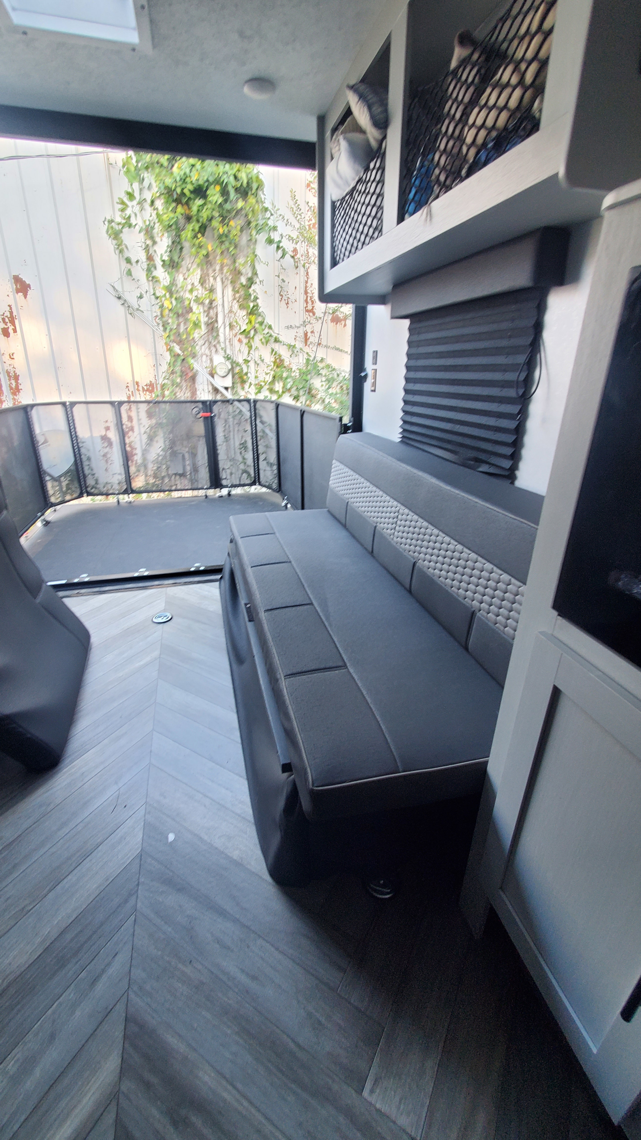Spacious RV rental interior featuring a versatile rear patio, comfy seating, smart mesh storage, and stylish herringbone flooring.. Forest River Wildwood 2022