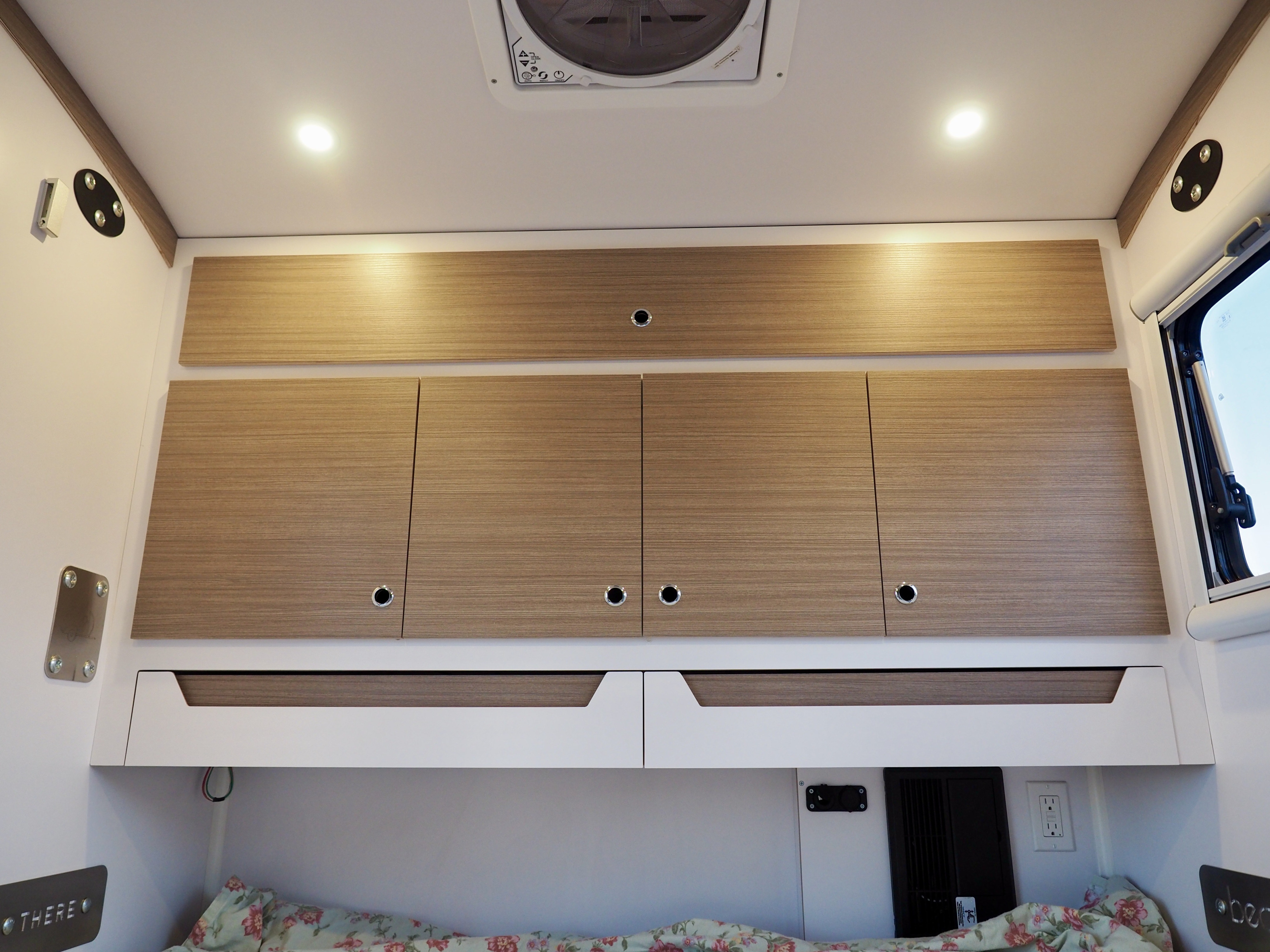 Inside an RV rental: modern wood cabinets, bright LED lighting, and a cozy bed, designed for comfortable travel and storage.. Bean Trailer Meaner Bean 2023