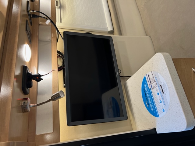 RV rental: A compact interior features a vertically mounted monitor, wall lights, and a solid-surface countertop.. Forest River Coachmen Nova 2022