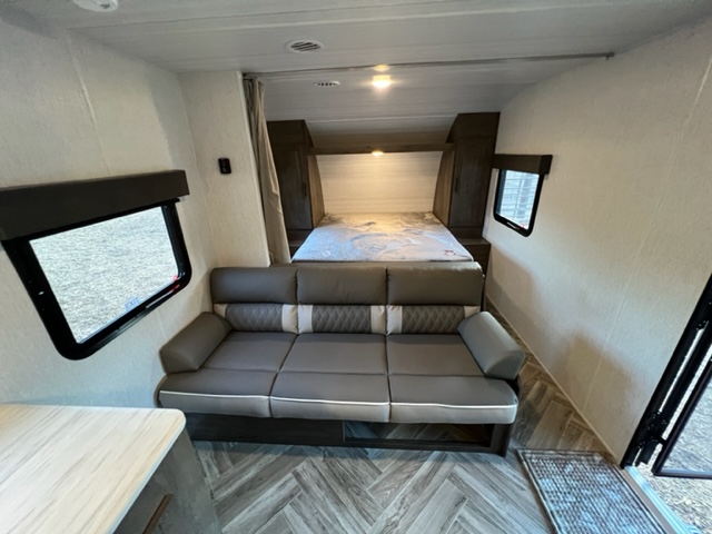Inside this RV rental: a spacious living area with a sofa, bed, kitchen counter, and ample windows for light.. Forest River Evo Select 268BH 2022