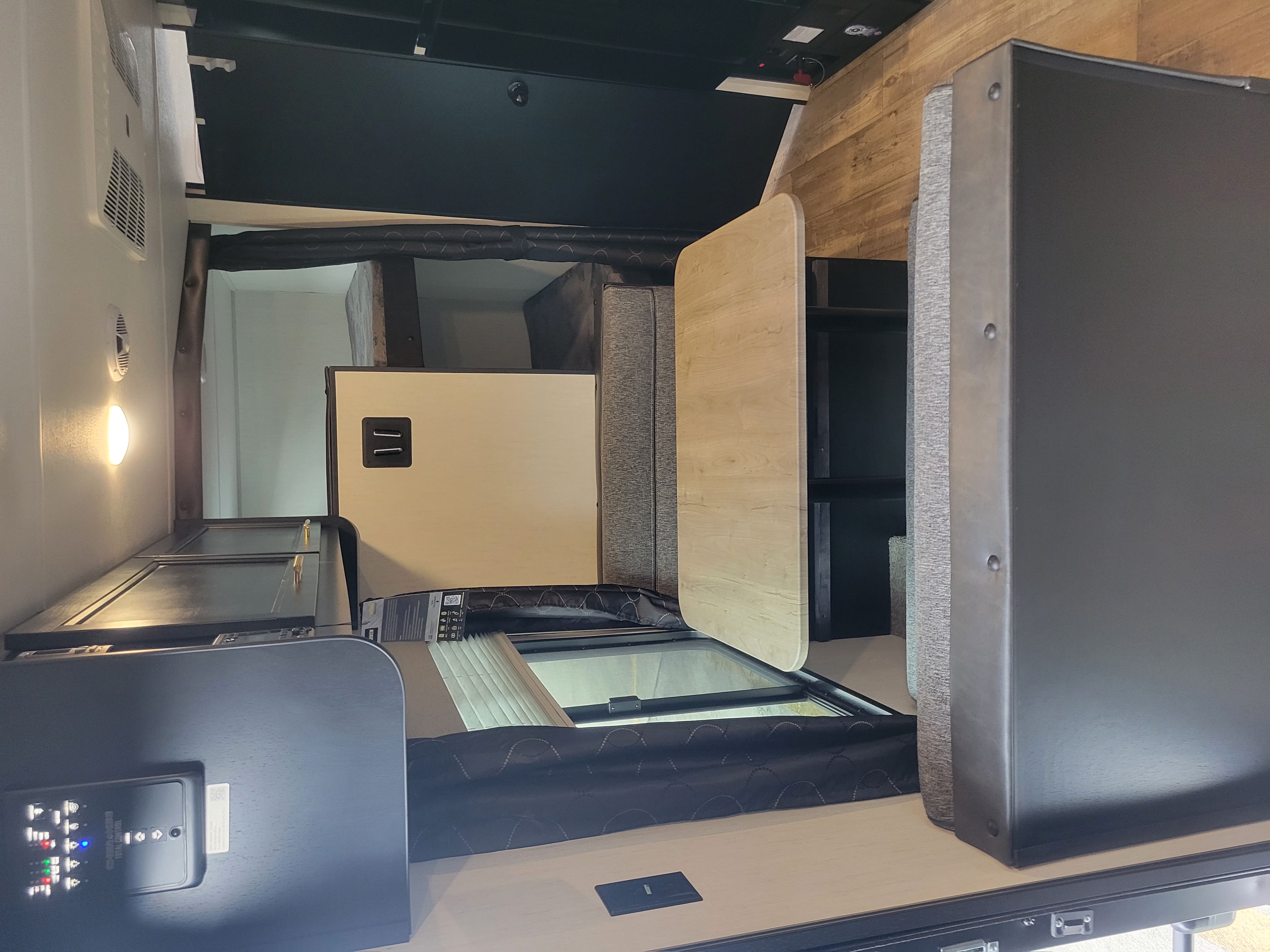 Well-appointed RV rental interior with convertible dining/bed, cushioned seating, and control panel for comfort.. Forest River Cherokee Grey Wolf Special Edition 2022