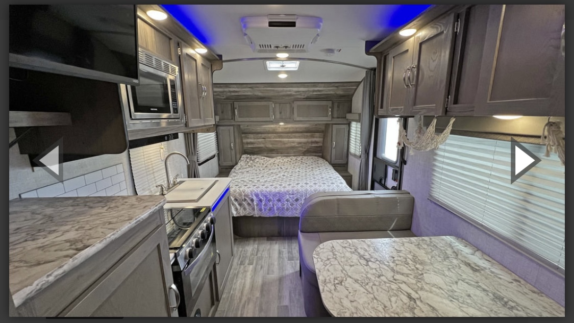 Spacious modern RV rental interior, featuring a kitchen, dinette, and comfortable bedroom area.. Gulf Stream Vista Cruiser 2022