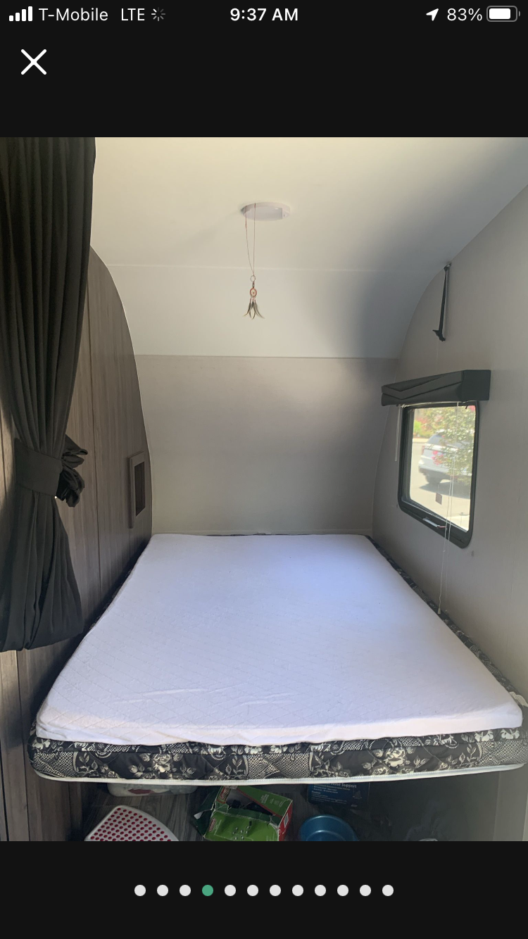 Cozy RV rental sleeping area featuring a spacious bed, window, and under-bed storage.. Pacific Coachworks Powerlite 2020