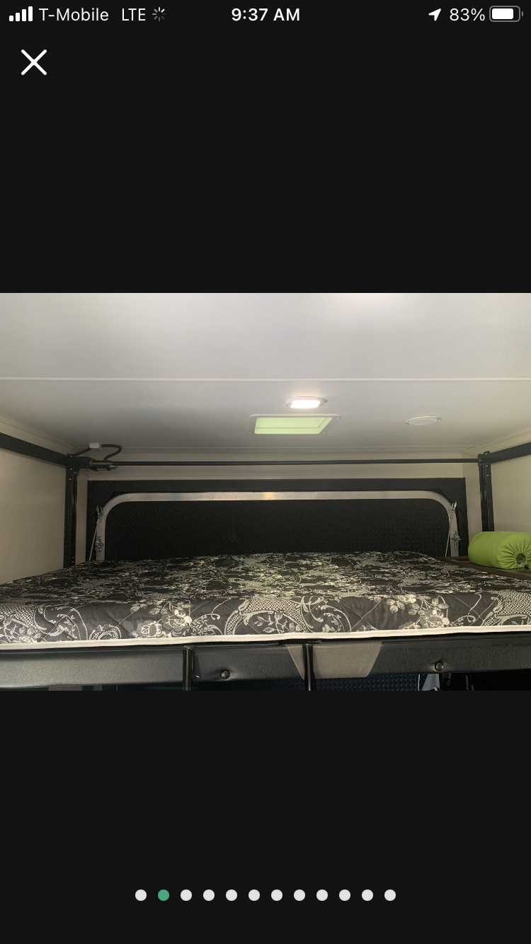 RV rental bunk bed interior: clean sleeping area with patterned mattress, light fixture, and skylight.. Pacific Coachworks Powerlite 2020
