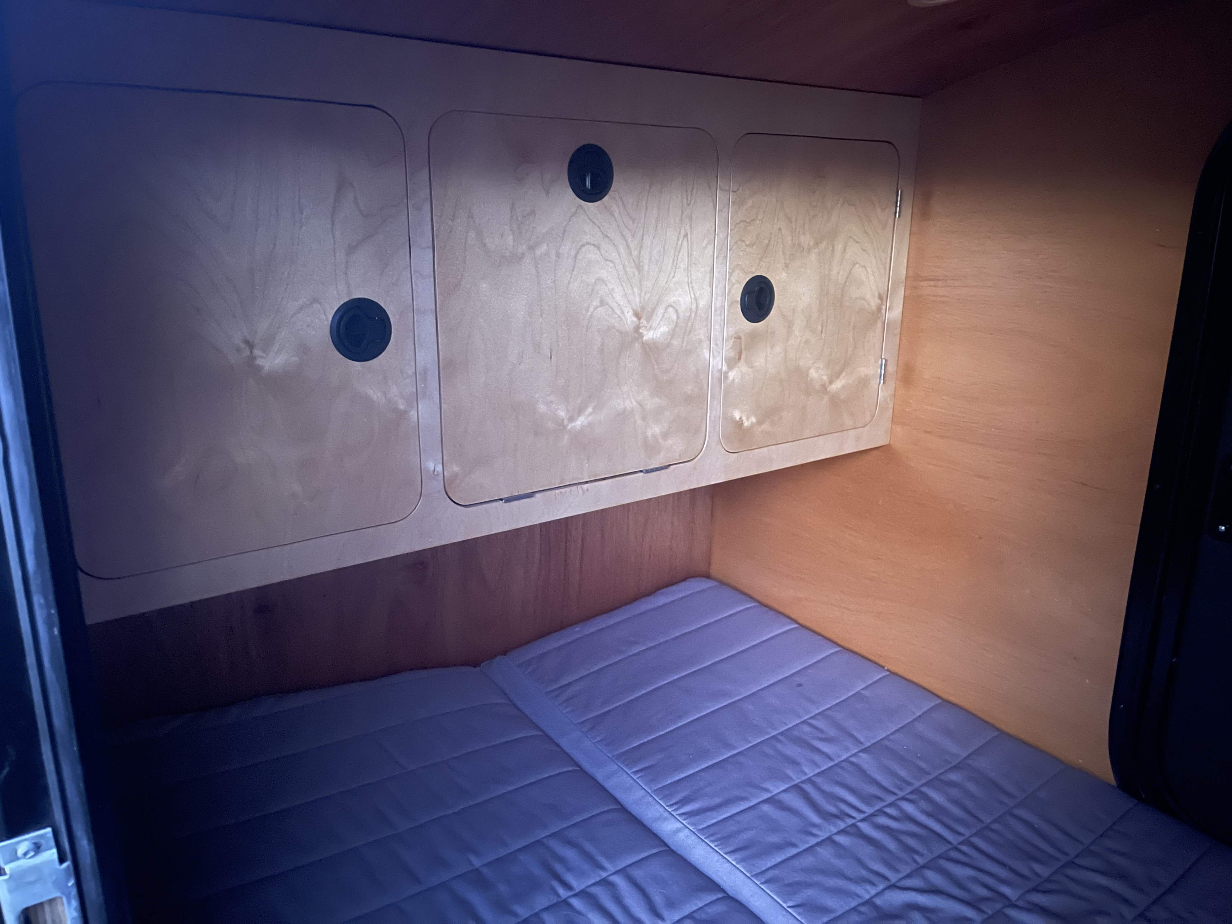 RV rental interior: compact sleeping area with blue mattress and wood storage cabinets.. Oracle Teardrops Teardrop 2020