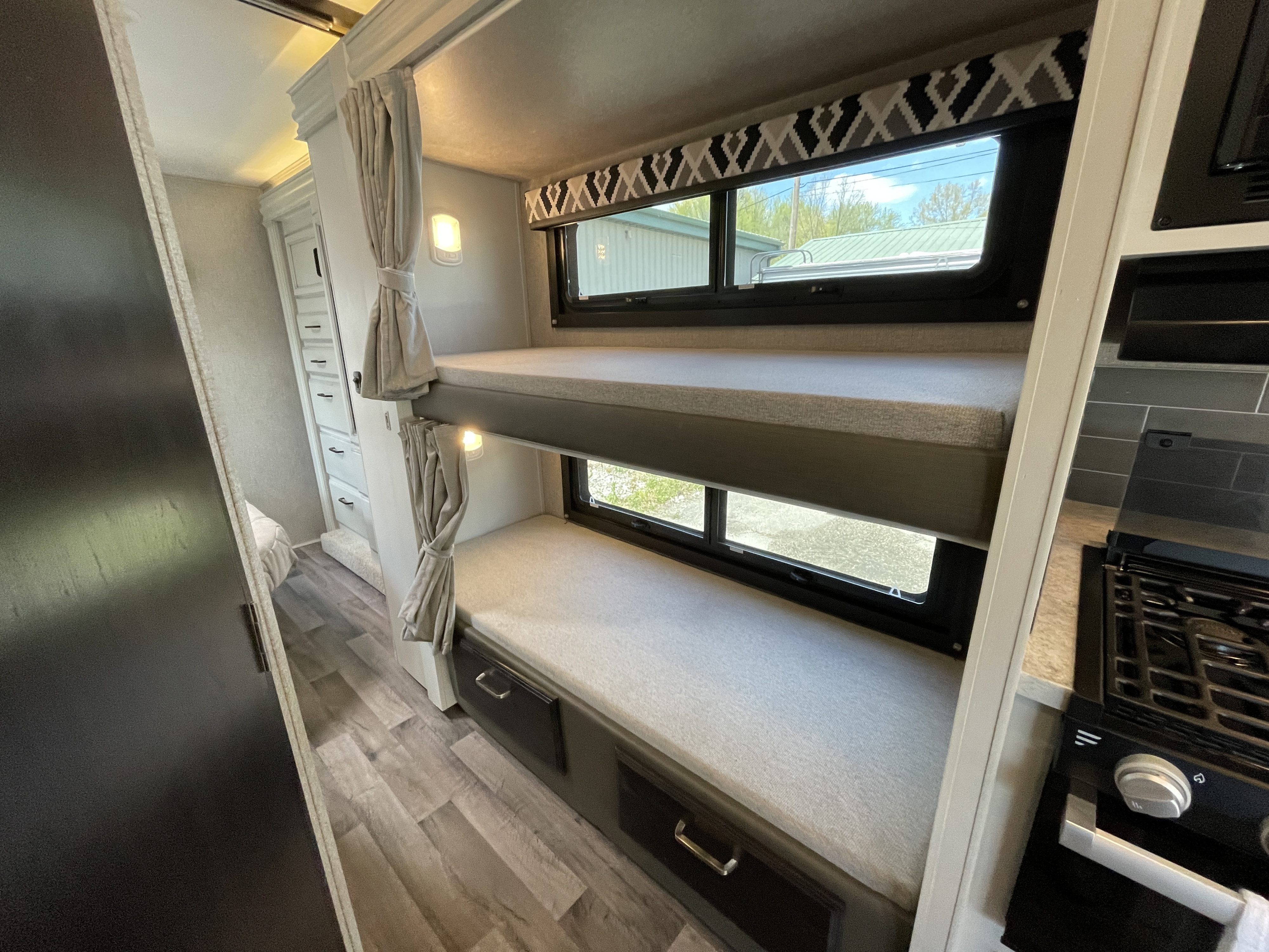 Explore this RV rental's comfy bunk beds, ample windows, and handy kitchen stove, perfect for family adventures.. Jayco Redhawk 2022