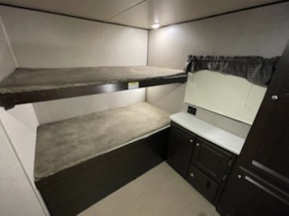 View the bunk bed sleeping area and small counter inside this RV rental, perfect for family travel adventures.. prowler 33PBHS 2019