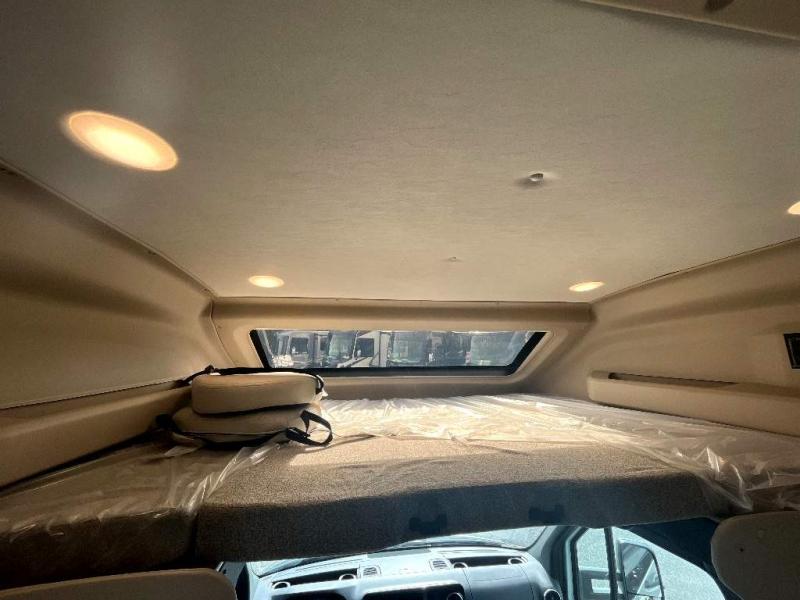 RV rental overhead bunk bed area, showing a new mattress, window, and inviting lights, ready for your road trip.. Entegra Coach Qwest 2023