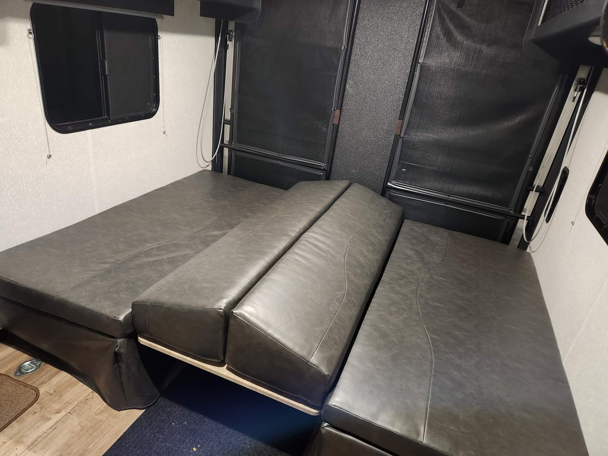 RV rental: Gray convertible seating converts to beds in this toy hauler interior.. Forest River Cherokee Grey Wolf 2022