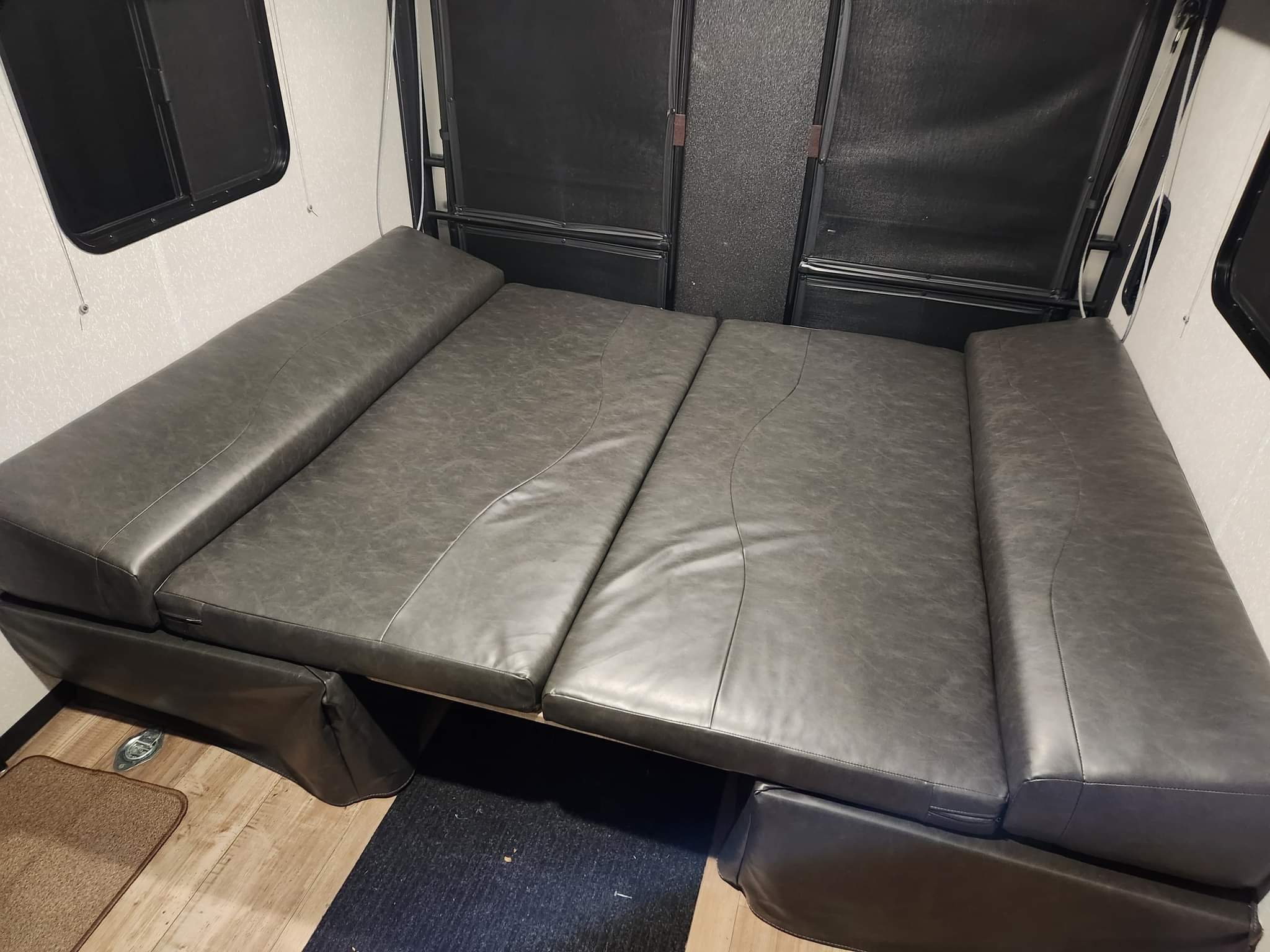 RV rental interior with versatile gray upholstered convertible seating, doubling as beds.. Forest River Cherokee Grey Wolf 2022
