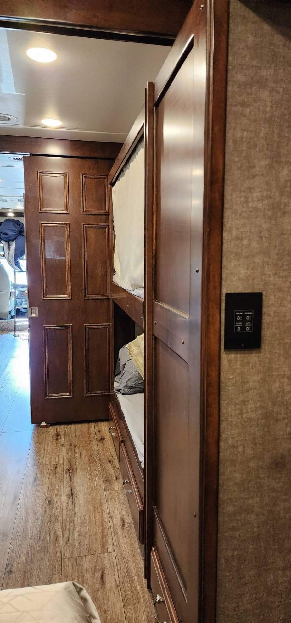 RV rental: detailed view of comfortable wooden bunk beds with bedding, wood floors, and a partially open sliding door.. Renegade Custom Coaches Verona 2022