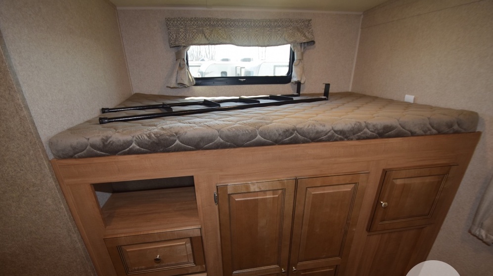 RV rental bunk bed area featuring a comfy mattress, under-bed storage cabinets, and a window.. Forest River Rockwood Ultra Lite 2019