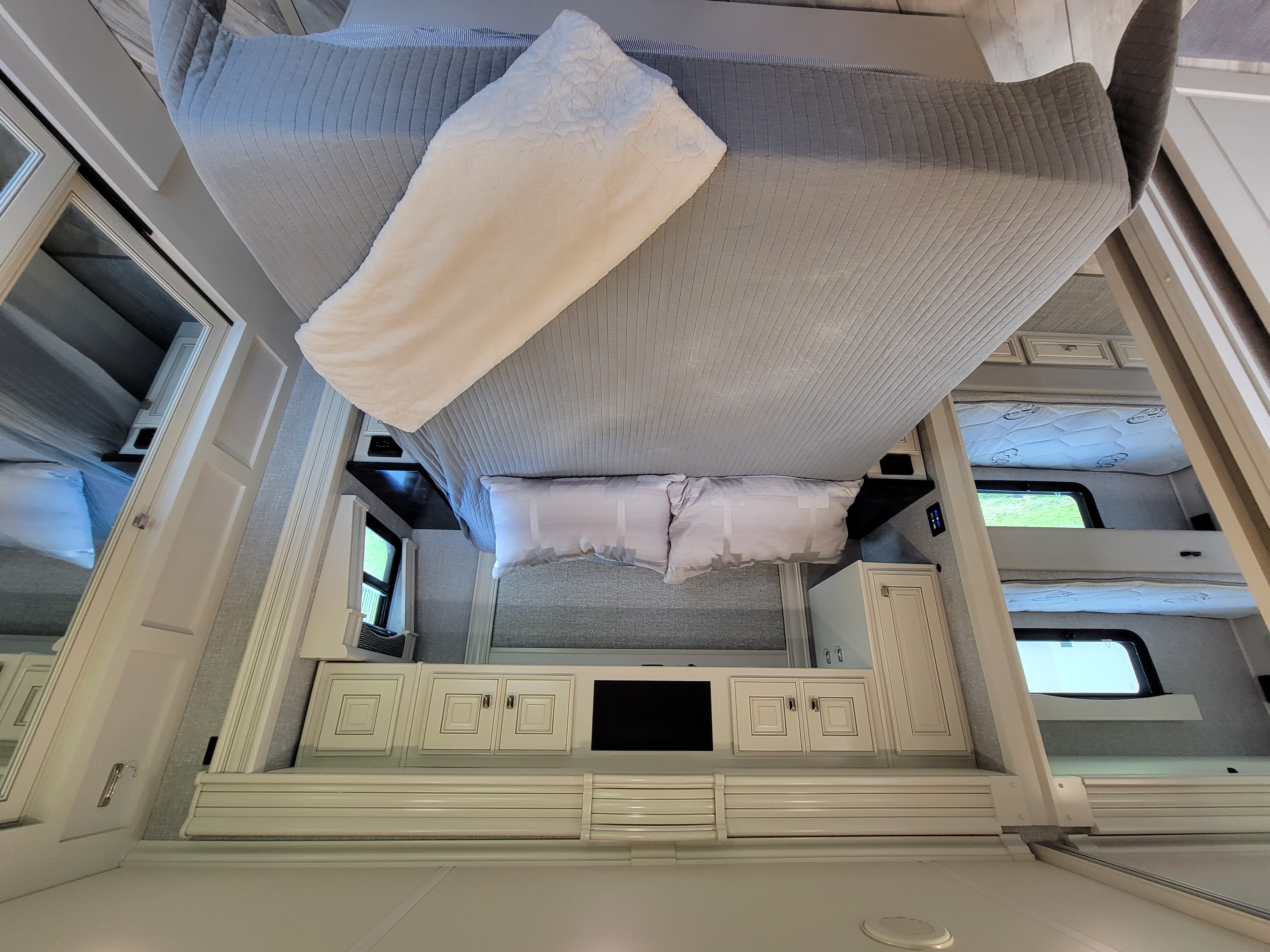 Spacious RV rental bedroom showcasing a large bed, built-in cabinetry, and comfortable bunk beds, perfect for family travel.. Fleetwood Other 2022