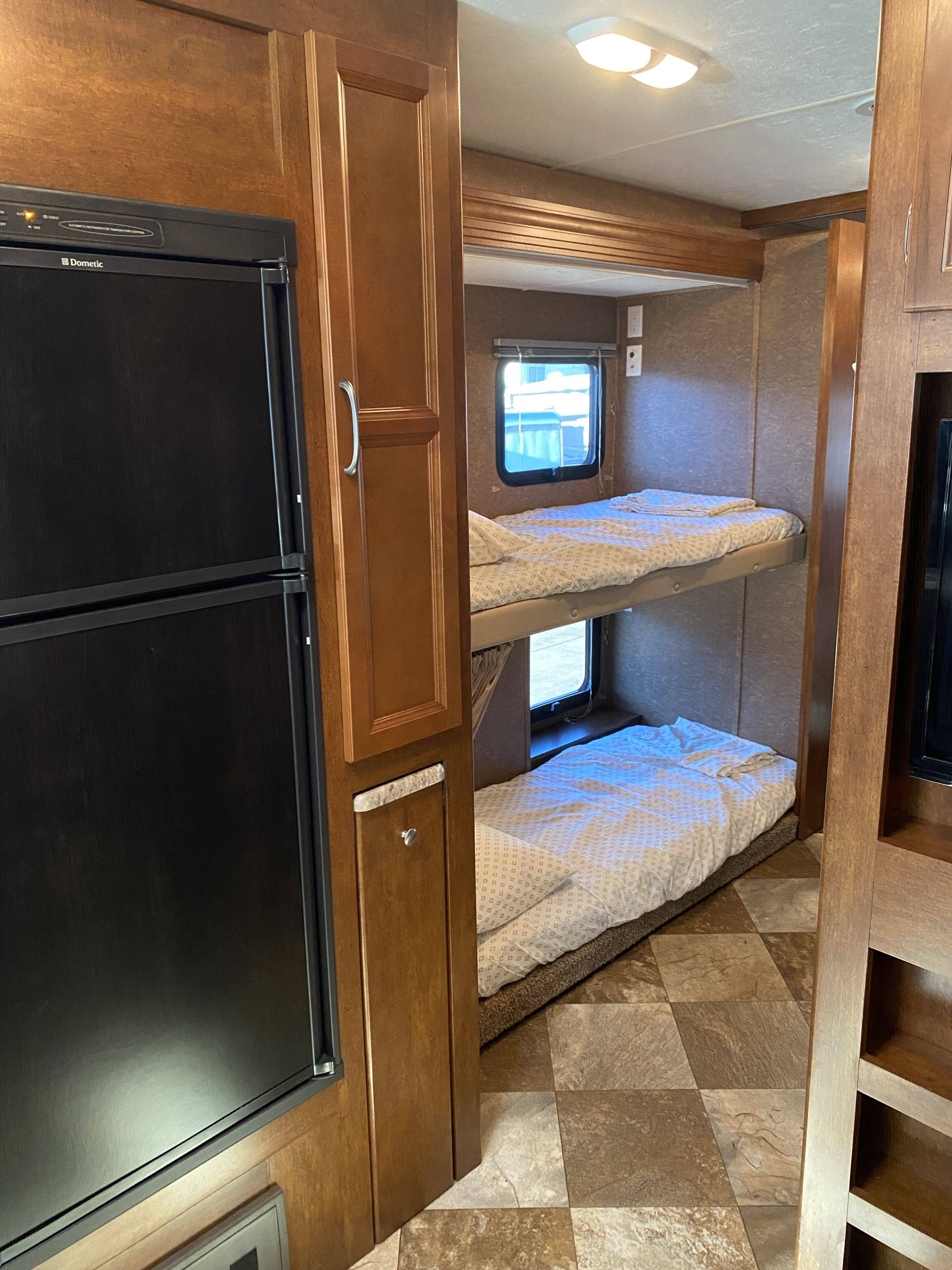 Inside an RV rental: features bunk beds, a Dometic fridge, and wood cabinetry for a comfortable travel experience.. Forest River Coachmen Pursuit 2015