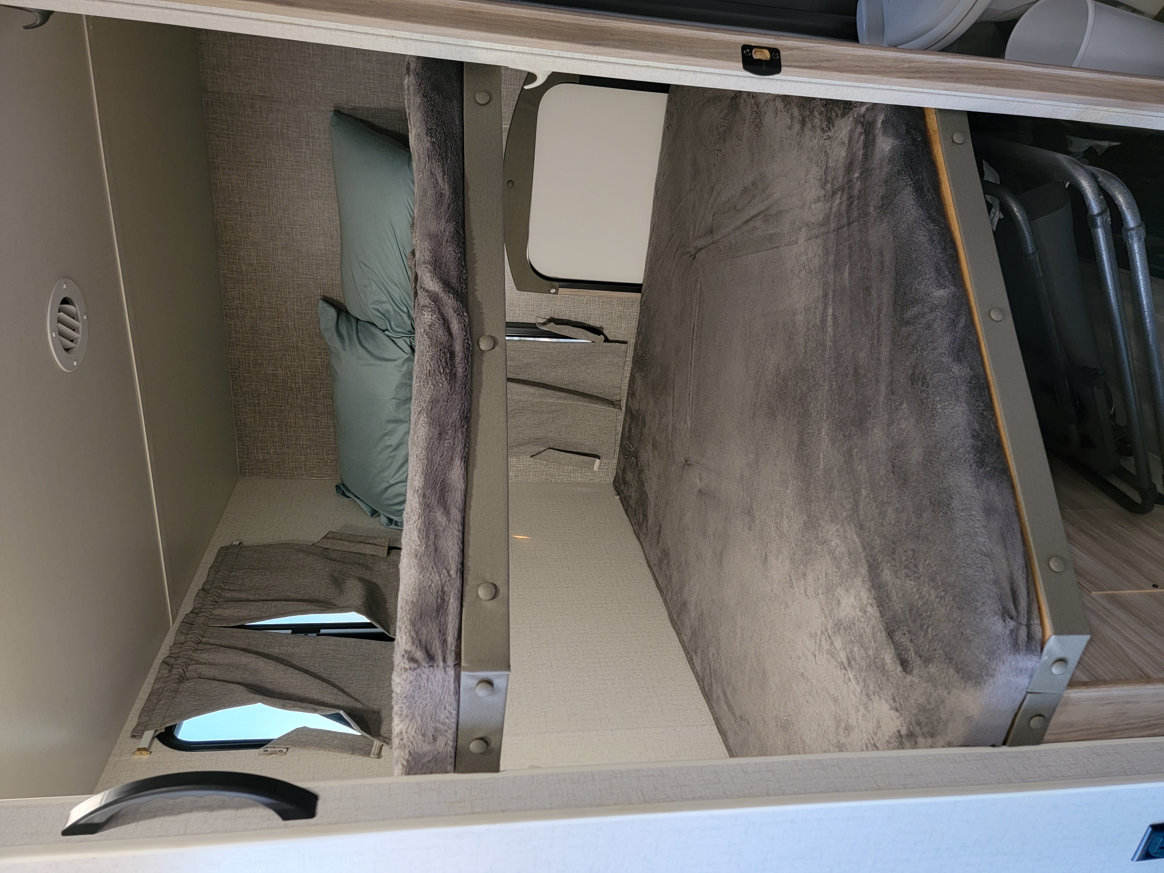 RV rental bunk beds: a compact sleeping area with upper and lower bunks, featuring soft bedding and practical storage below.. Winnebago Minnie Winnie 2022