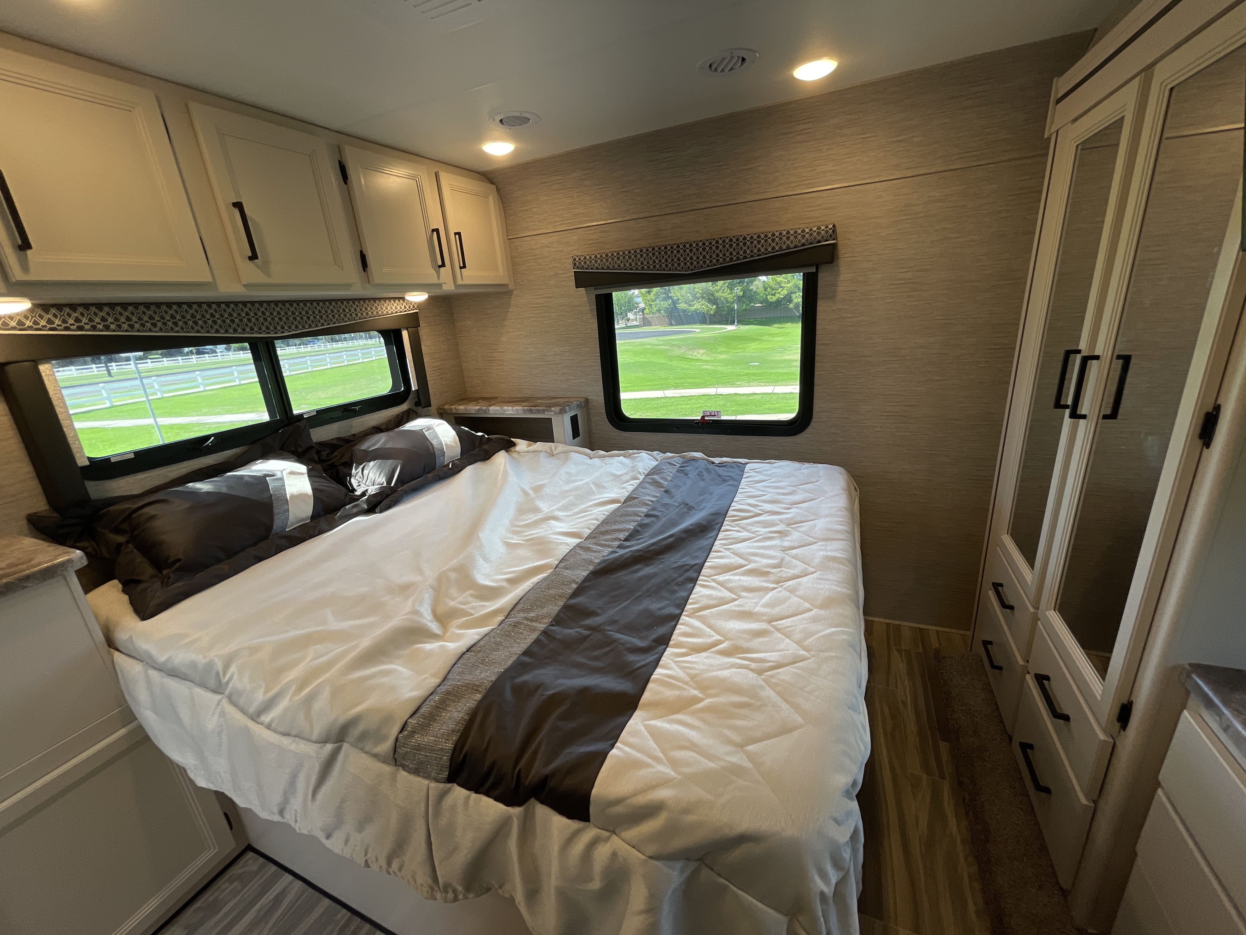 RV rental bedroom: A bright, modern space with a comfy bed, large windows for natural light, and storage.. Thor Motor Coach Four Winds 2023