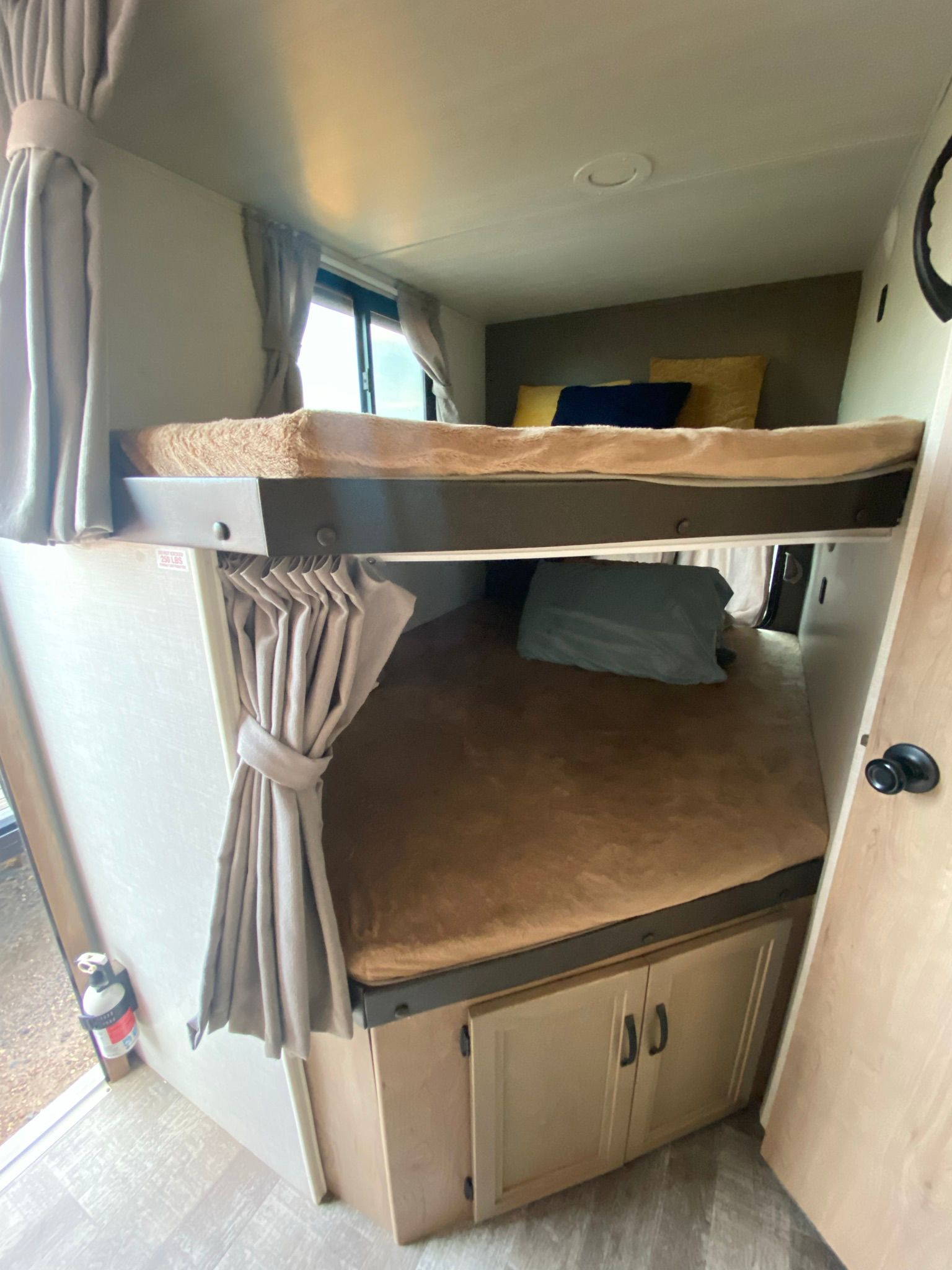 RV rental interior features cozy bunk beds, complete with curtains for privacy. A compact sleeping area for travel.. Winnebago Minnie Winnie 2021