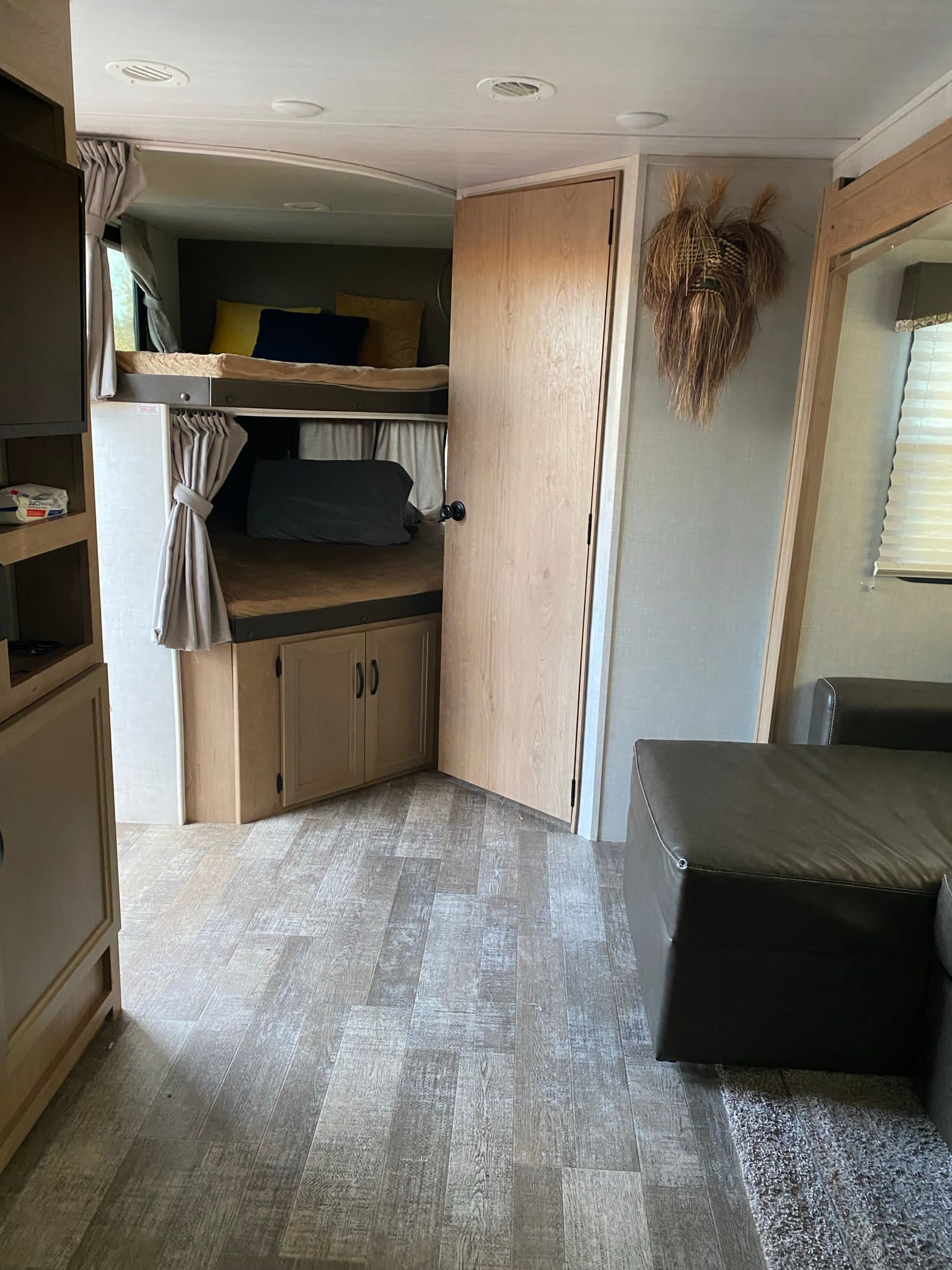 Experience a comfortable RV rental. This interior features compact bunk beds, a plush sofa, and durable wood-look flooring.. Winnebago Minnie Winnie 2021