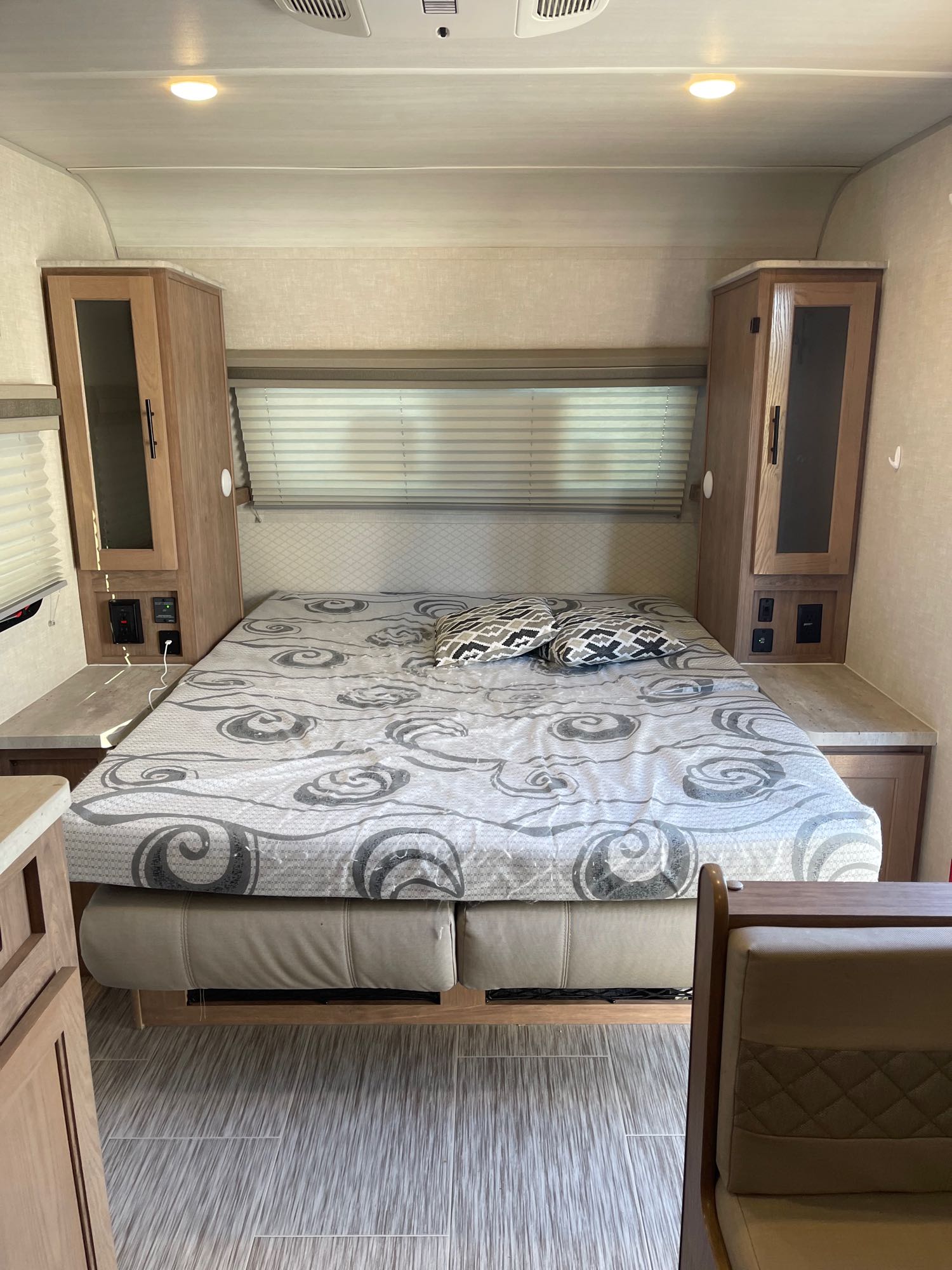 Cozy RV rental bedroom featuring a comfy bed with patterned bedding, built-in cabinets, and nightstands.. Forest River No Boundaries 19.3 2021